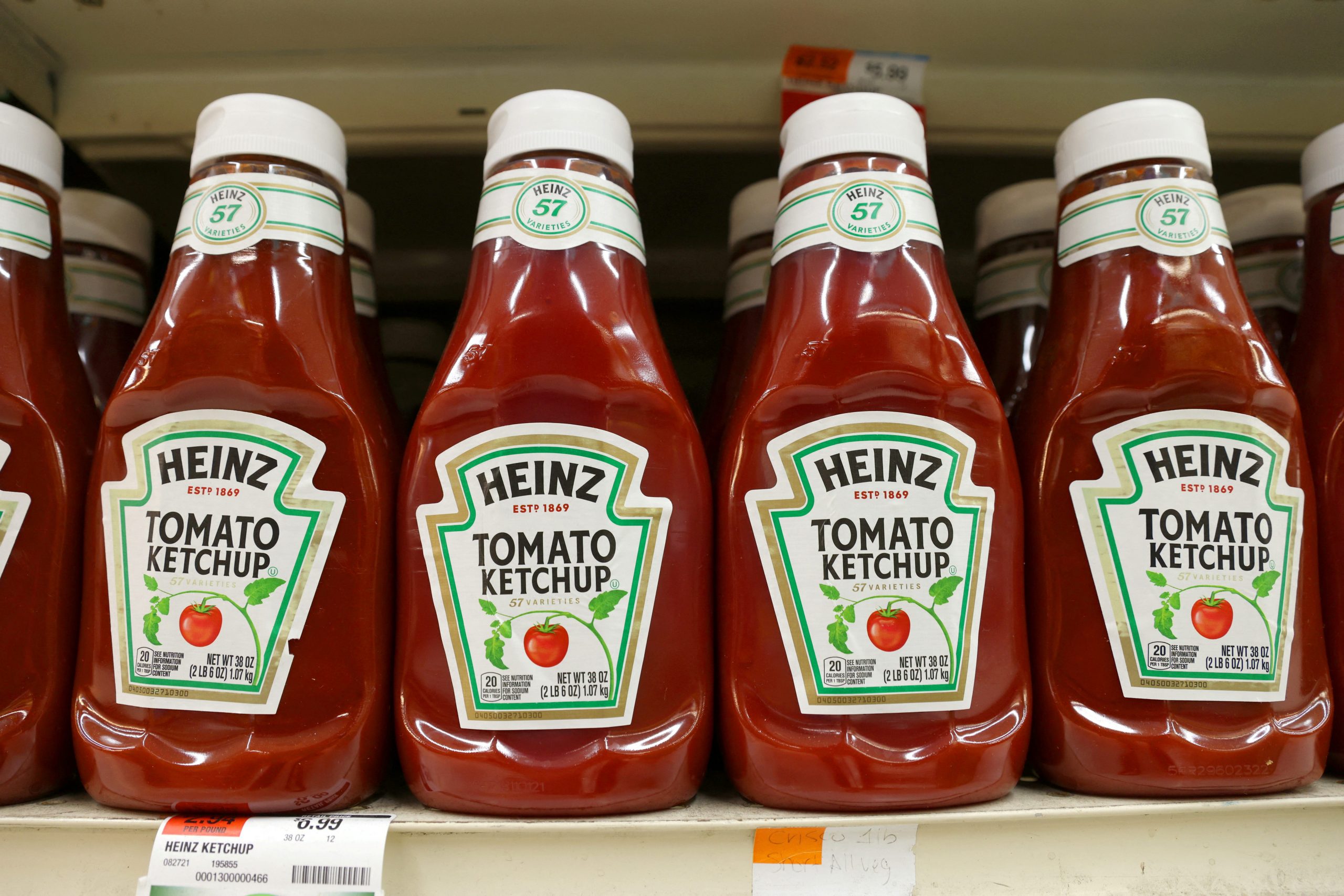 Bottles of Heinz ketchup, each bearing the number 57 on its label, sit on a grocery shelf.