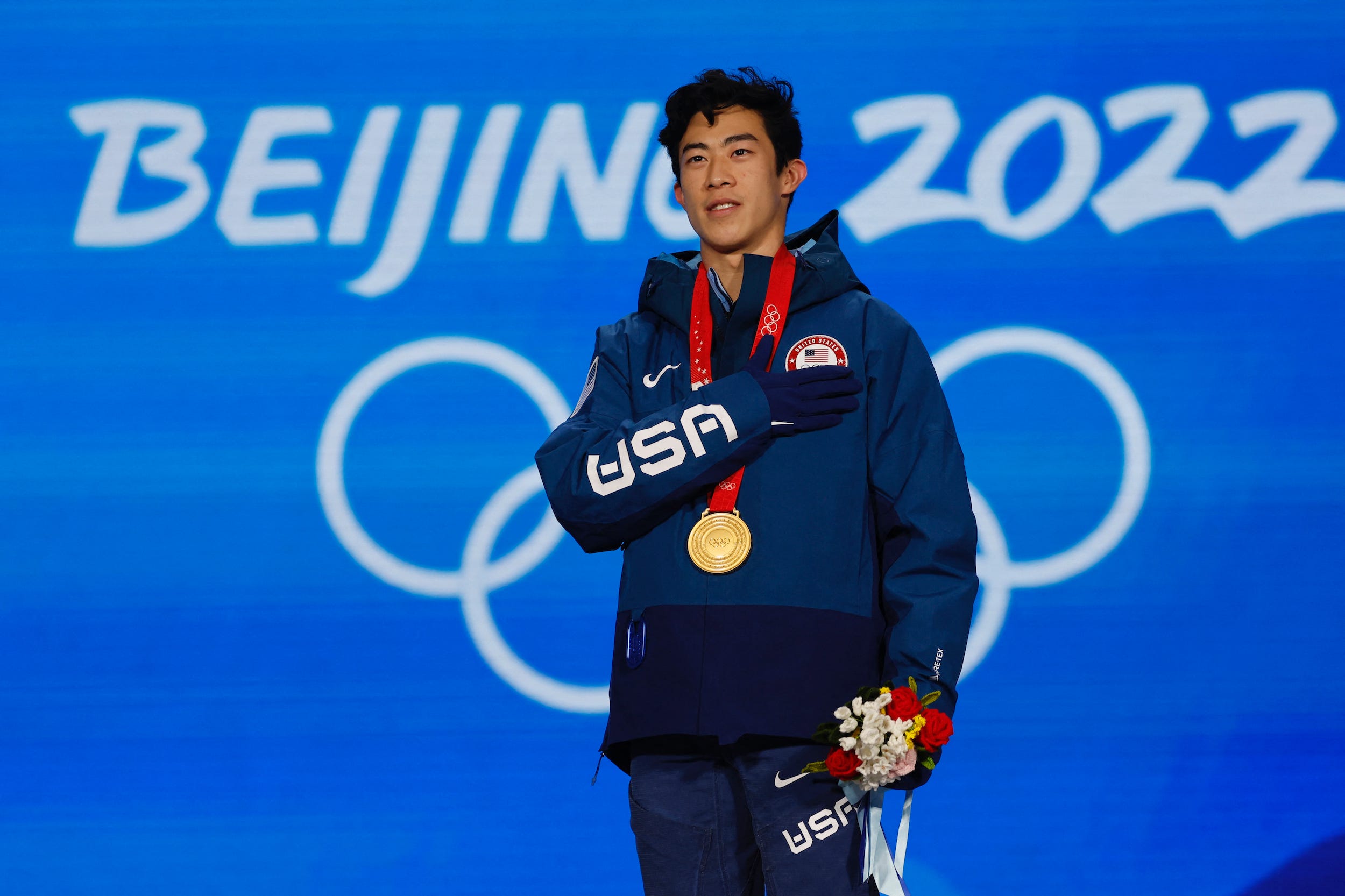 Nathan Chen poses with his gold medal from the 2022 Beijing Olympics.