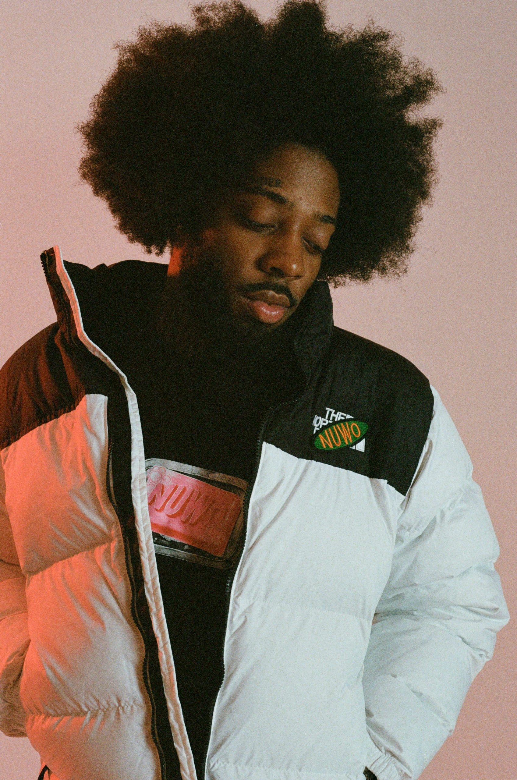 A person with an afro and white jacket