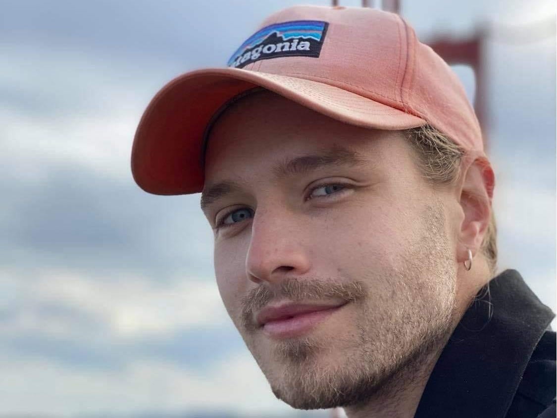 headshot of a man wearing a pink hat