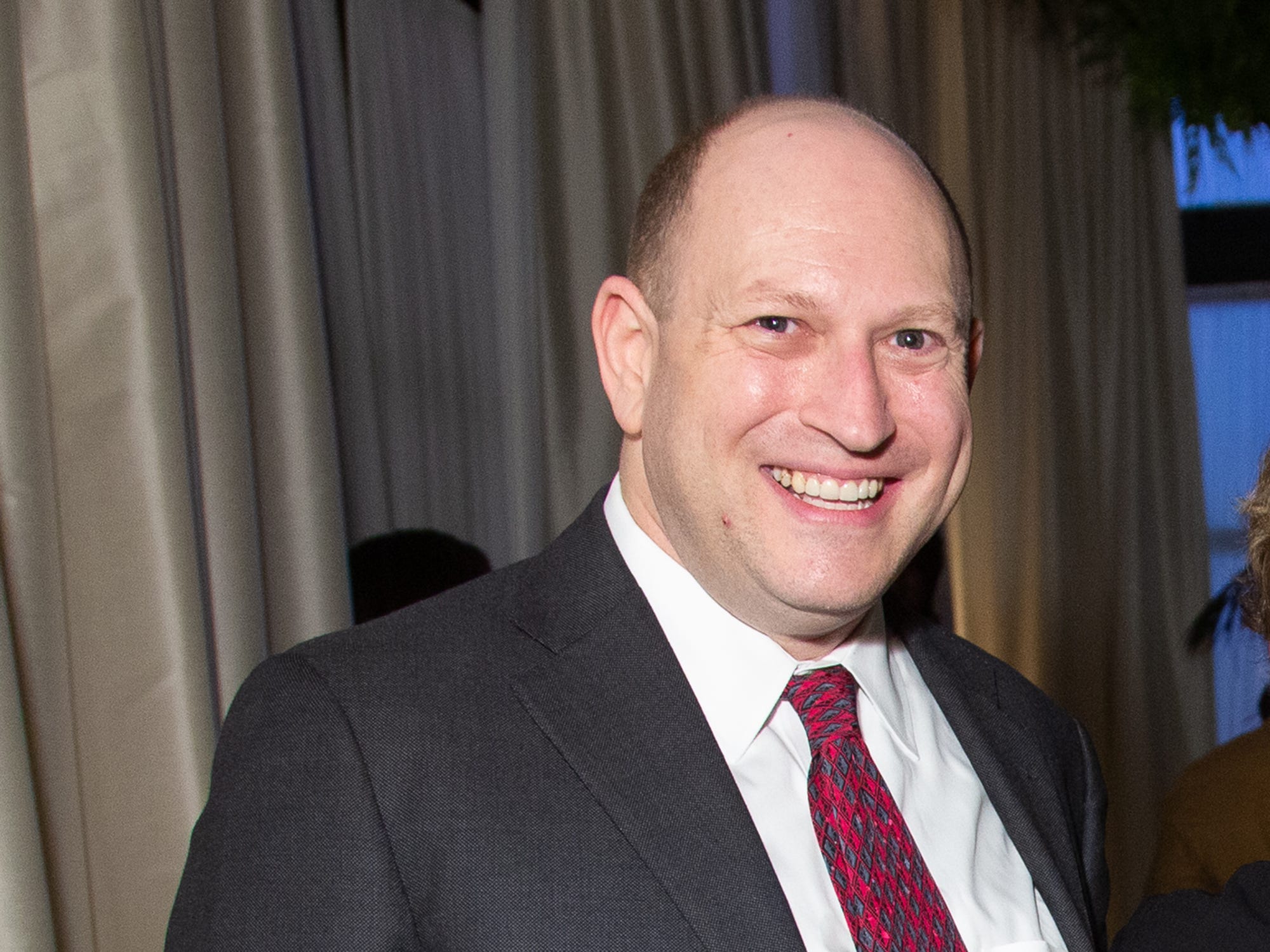 Scott Berkowitz wearing a suit and smiling at the camera.