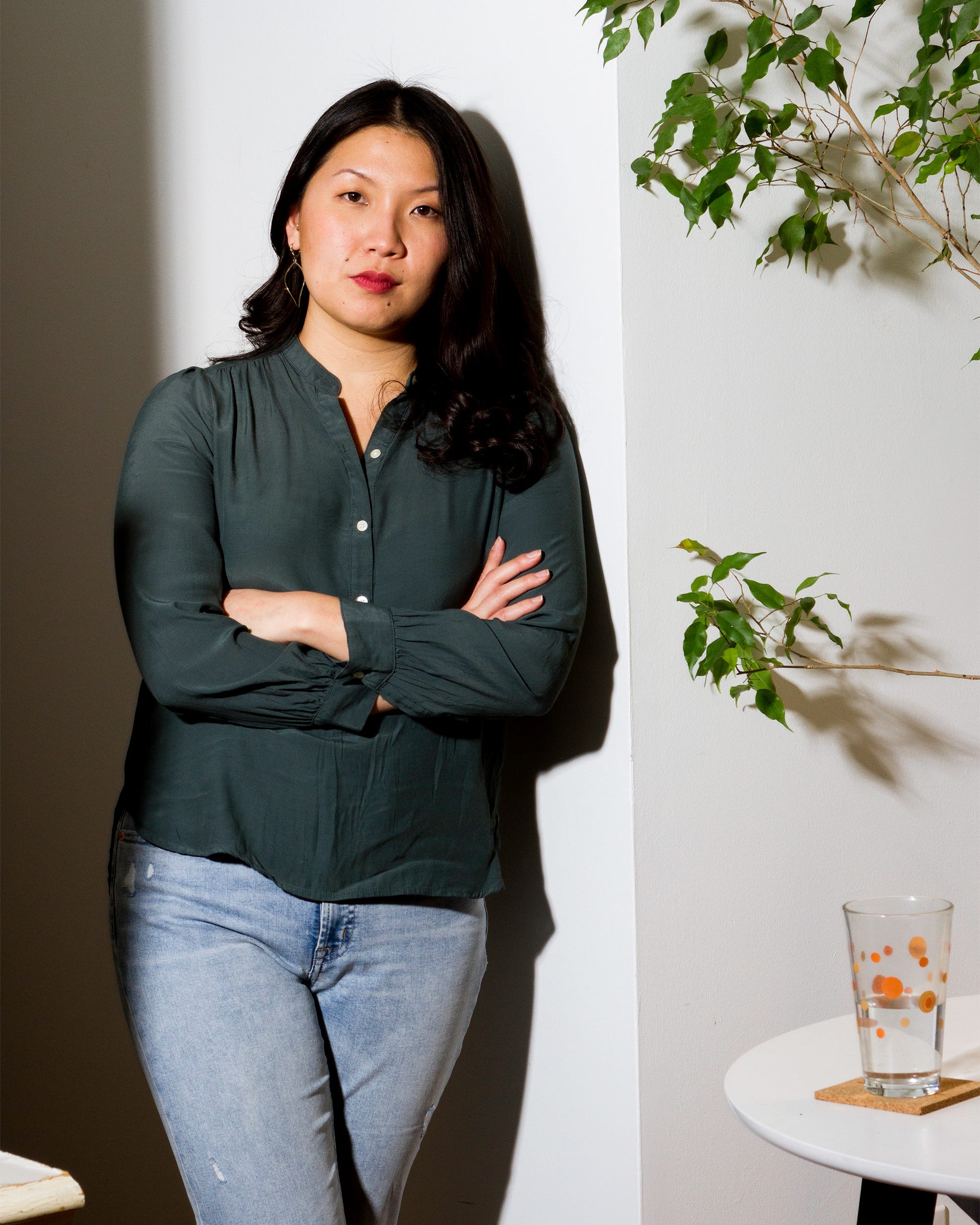 Jackii Wang leans against a wall with her arms crossed.