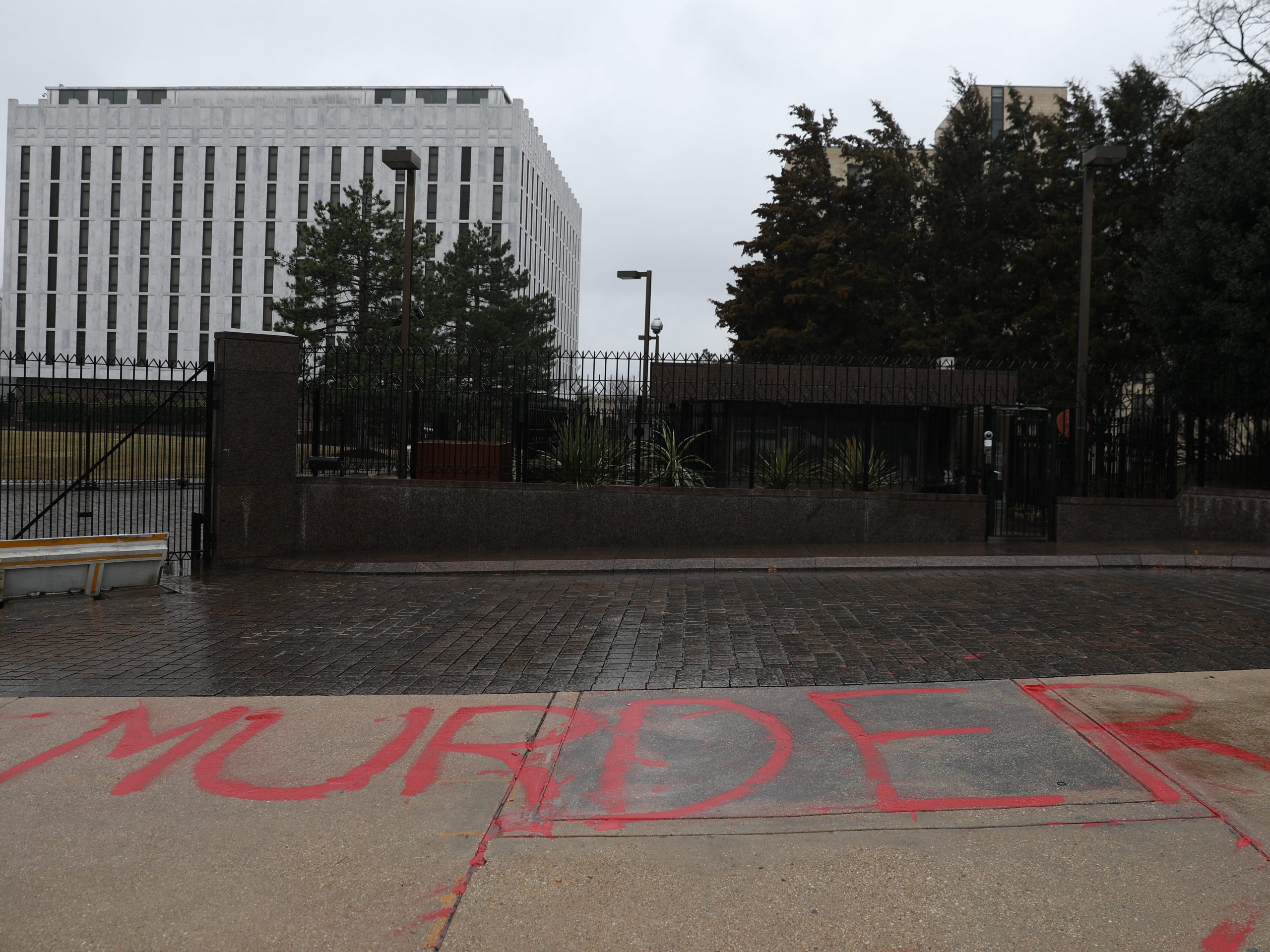 A woman writes "murder" in front of the Russia's Embassy in Washington to protest against Russian intervention in Ukraine, on February 24, 2022 in Washington, United States.