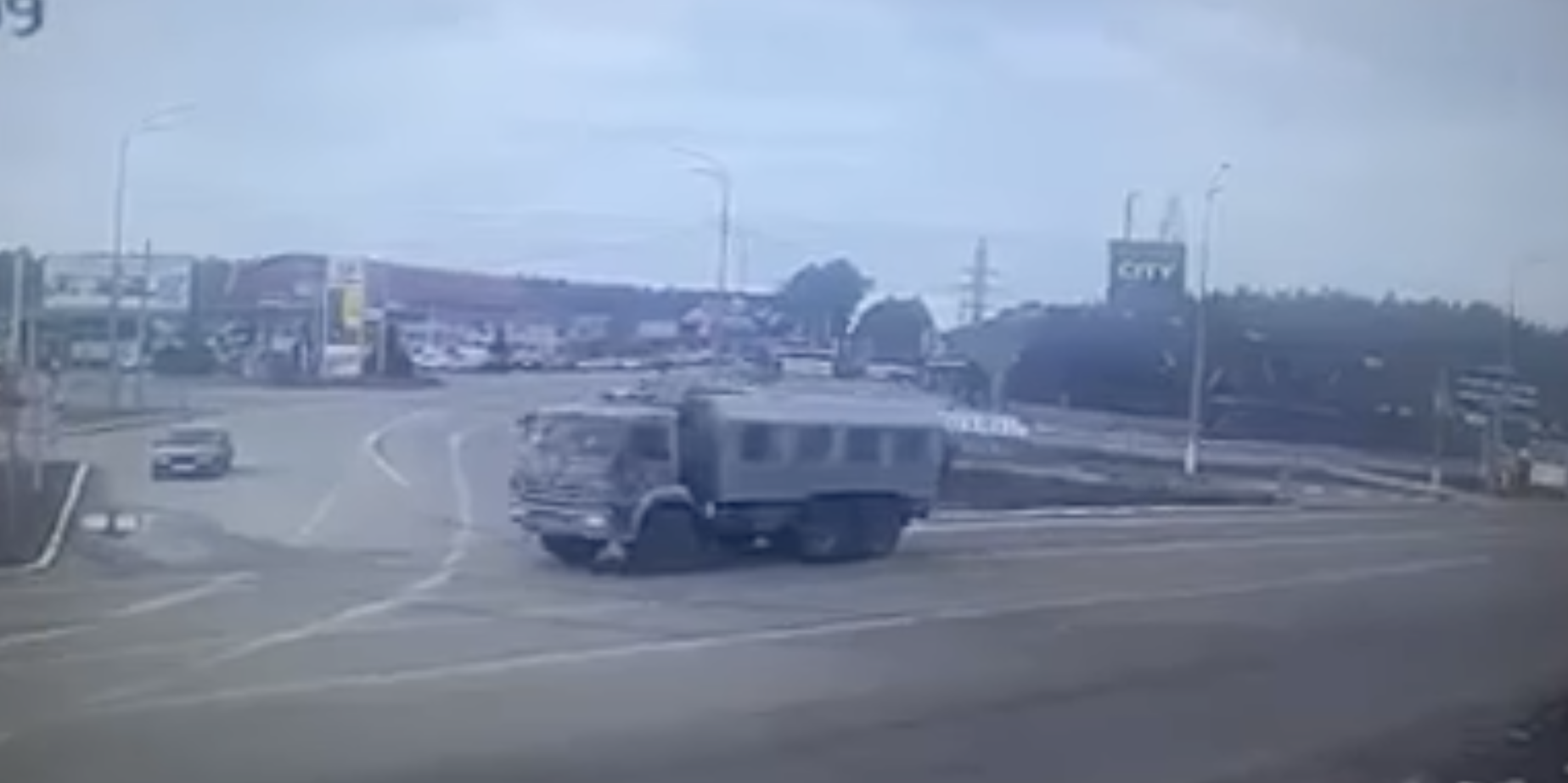 A still from a video of what appears to be a surveillance monitor, showing grainy video of a military vehicle.