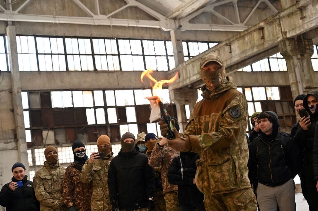 A military instructor teaches civilians to use Molotov cocktails during a training session at an abandoned factory in the Ukrainian capital of Kyiv on February 6, 2022.