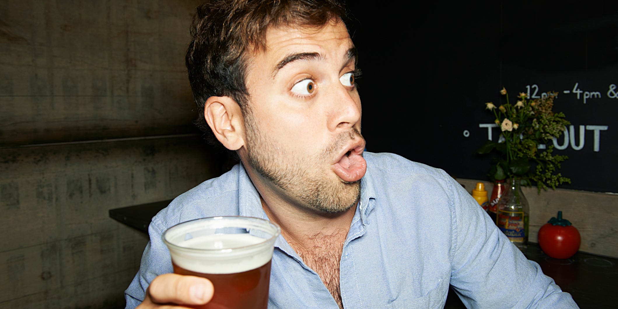 A man holds a beer in his hand.