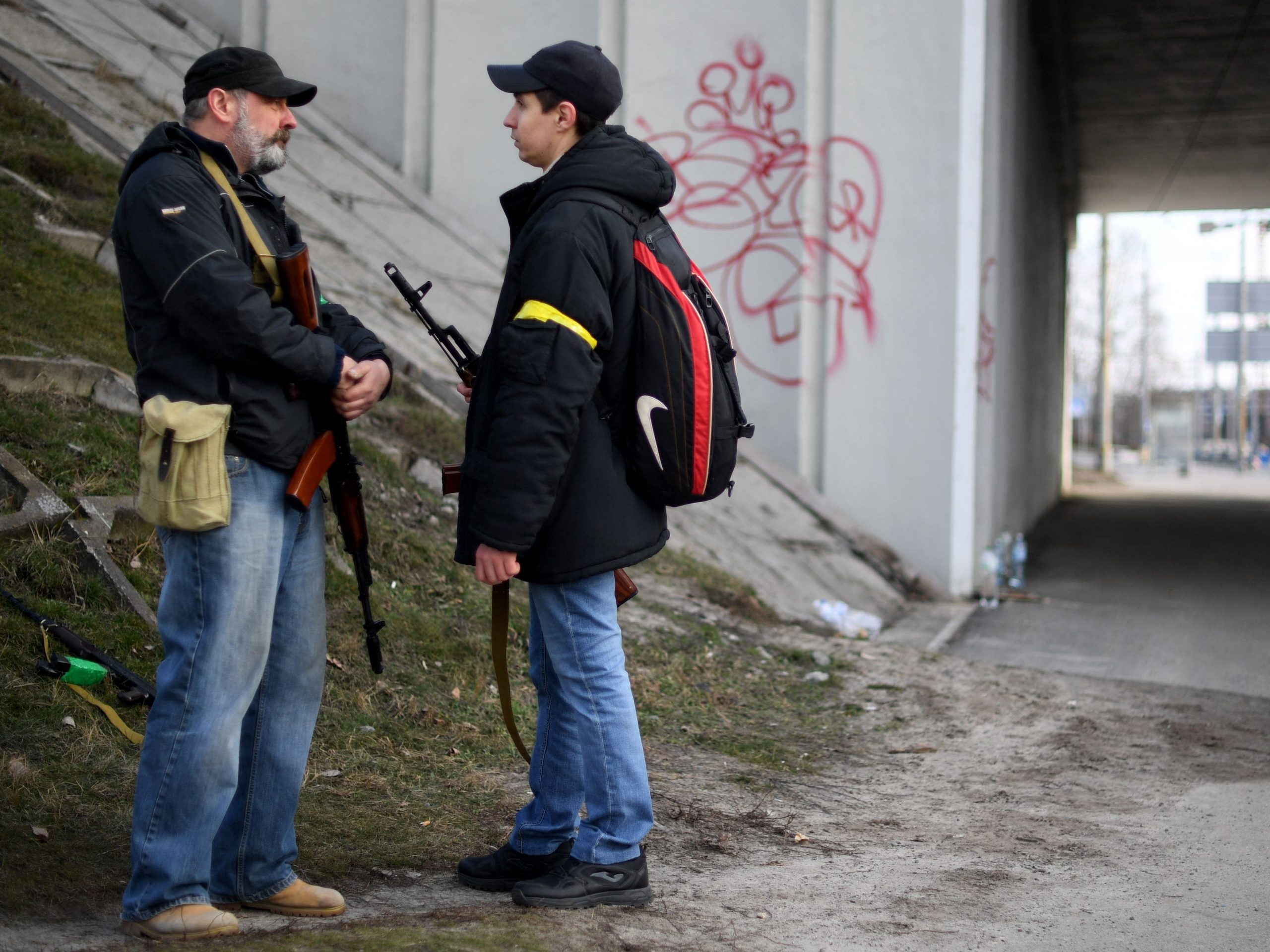 Volunteers, holding AK-47 rifles, protect a main road leading into Kyiv.