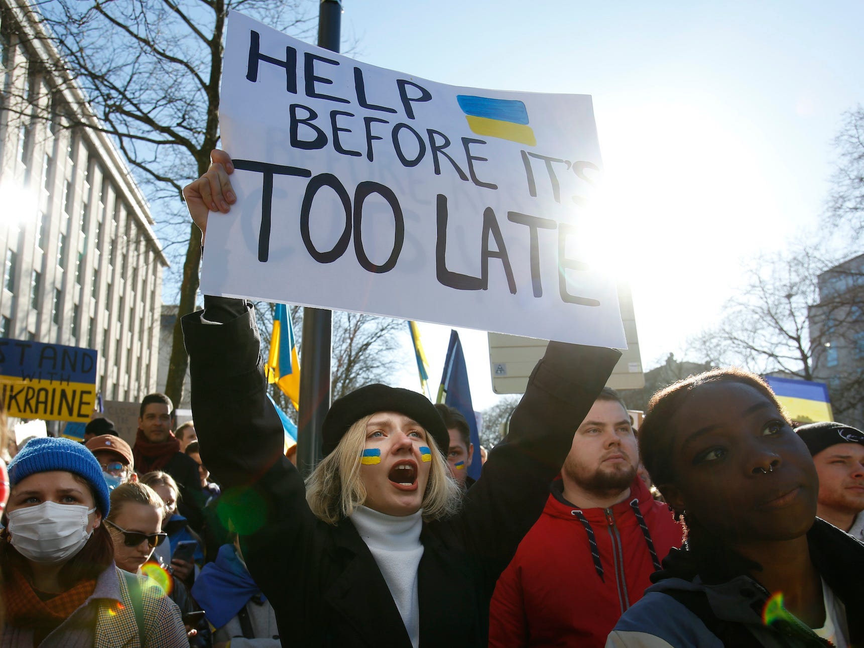 A protestor holds a sign during a demonstration against the Russian invasion of Ukraine, in Brussels, Saturday, Feb. 26, 2022.