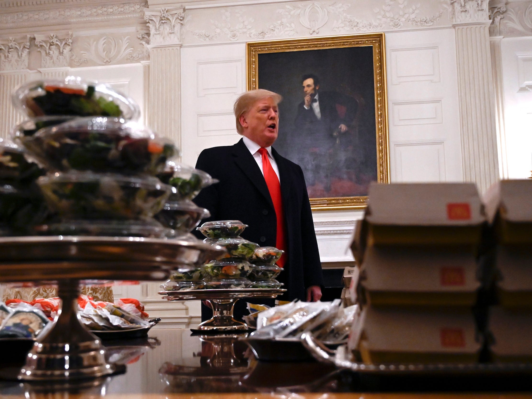 Former President Donald Trump talks to the press about the table full of fast food in the State Dining Room of the White House in Washington, Monday, Jan. 14, 2019, during a reception for the 2018 college football playoff National Champion Clemson Tigers.