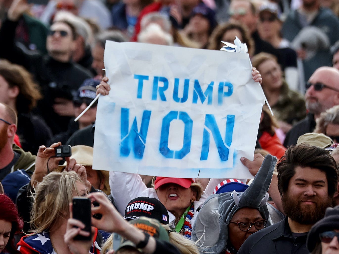 A supporter holds a 'Trump Won' sign at a rally by former President Donald Trump at the Canyon Moon Ranch festival grounds on January 15, 2022 in Florence, Arizona.