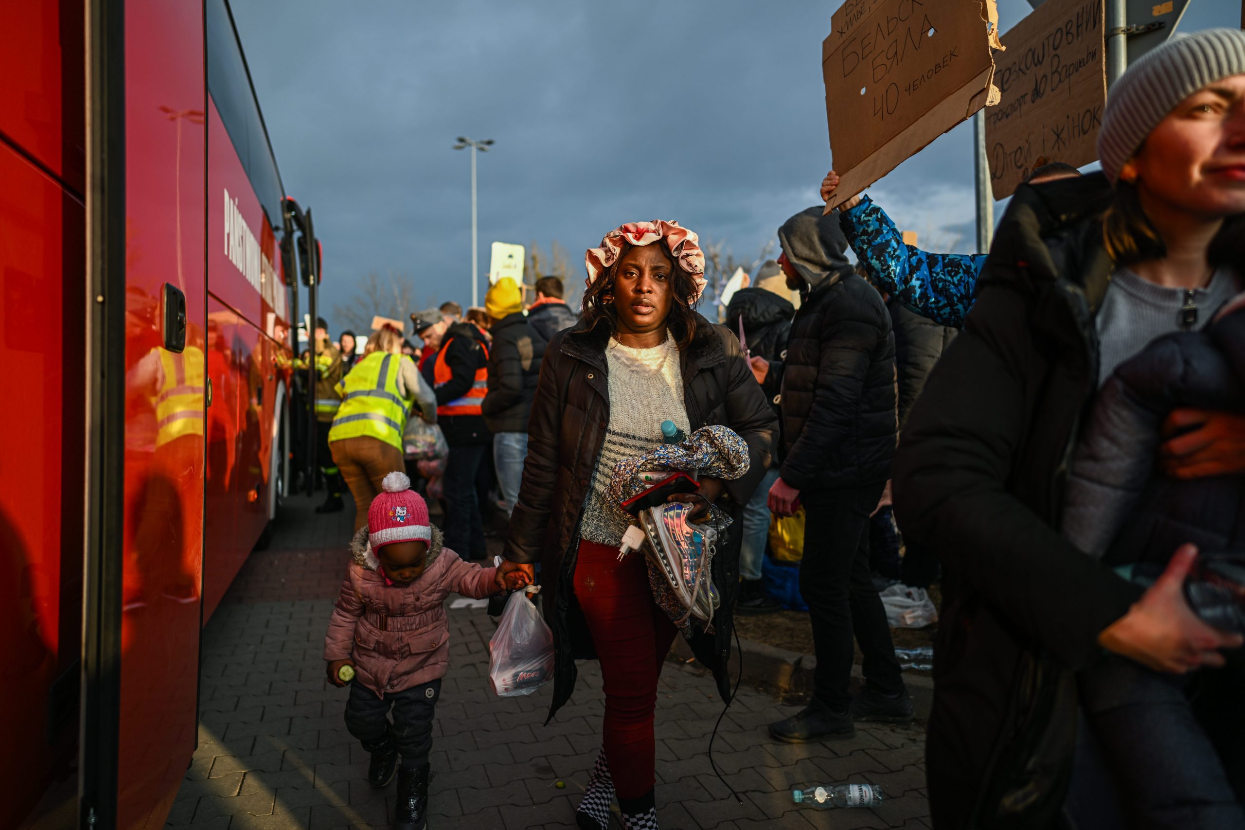 Nigerian citizens, Victoria and her daughter, Elvira arrive by bus to a supermarket parking lot from the Polish-Ukrainian border crossing February 26, 2022 in Przemysl, Poland