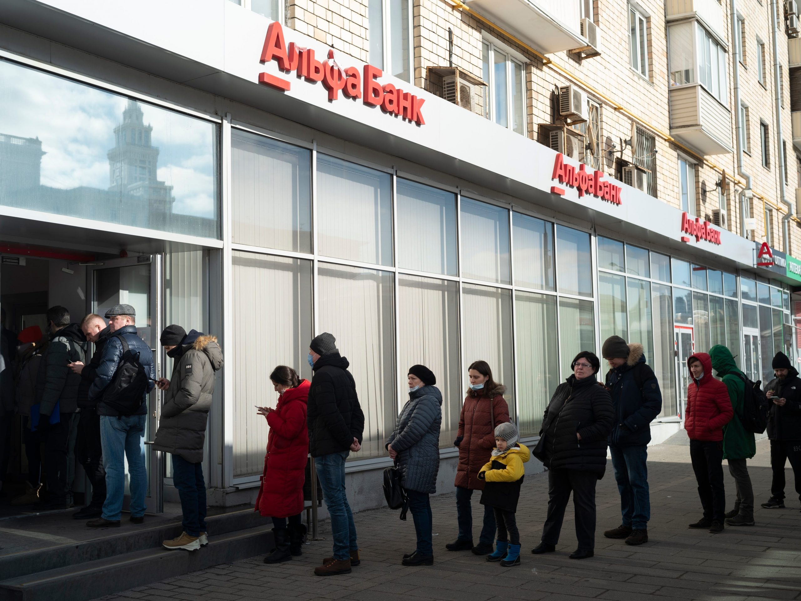 People stand in line to withdraw money from an ATM of Alfa Bank in Moscow, Russia, Sunday, Feb. 27, 2022.