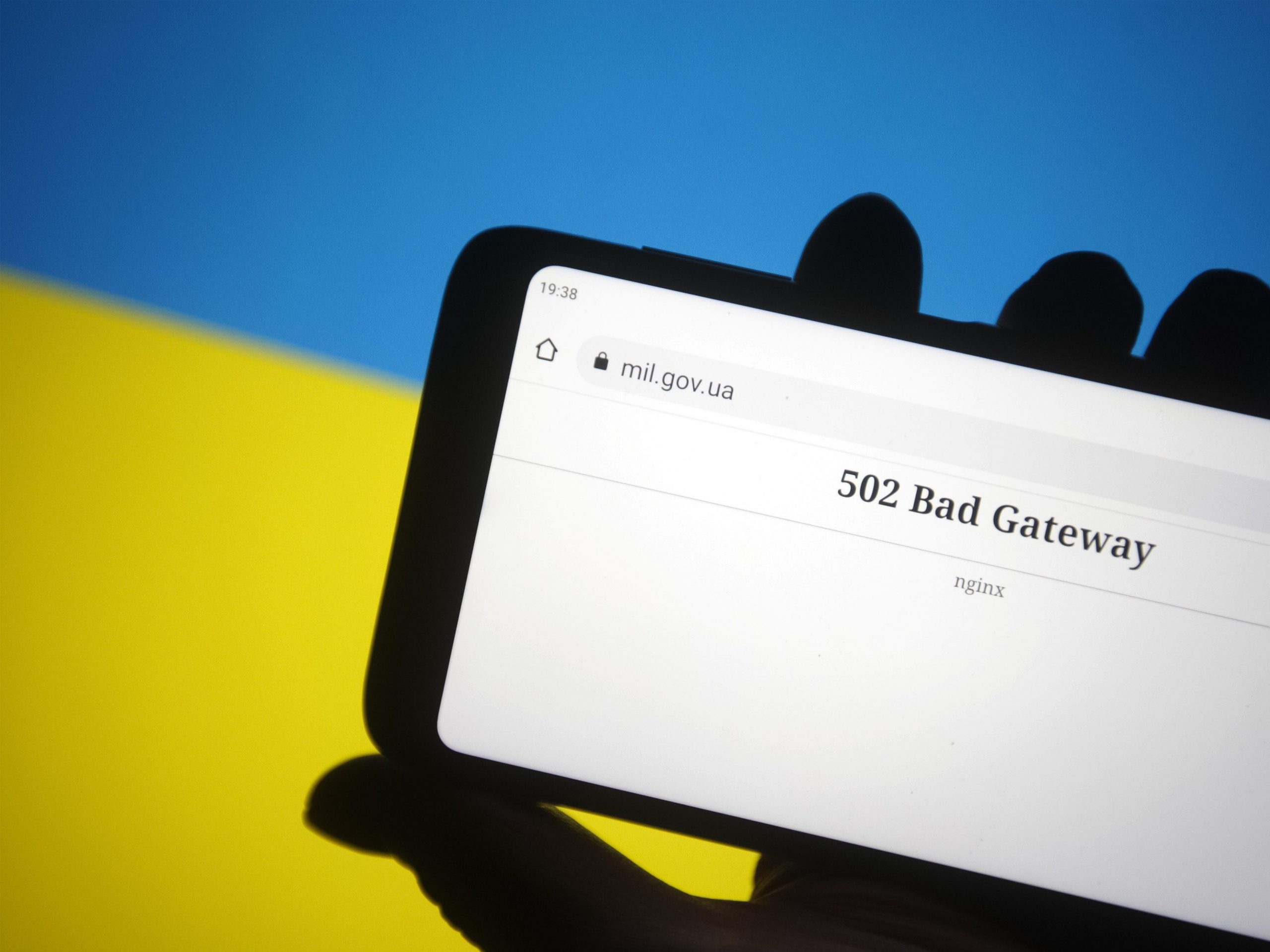 The 502 Bad Gateway message is seen on Ministry of Defence of Ukraine official webpage displayed on a smartphone screen and flag of Ukraine in the background.