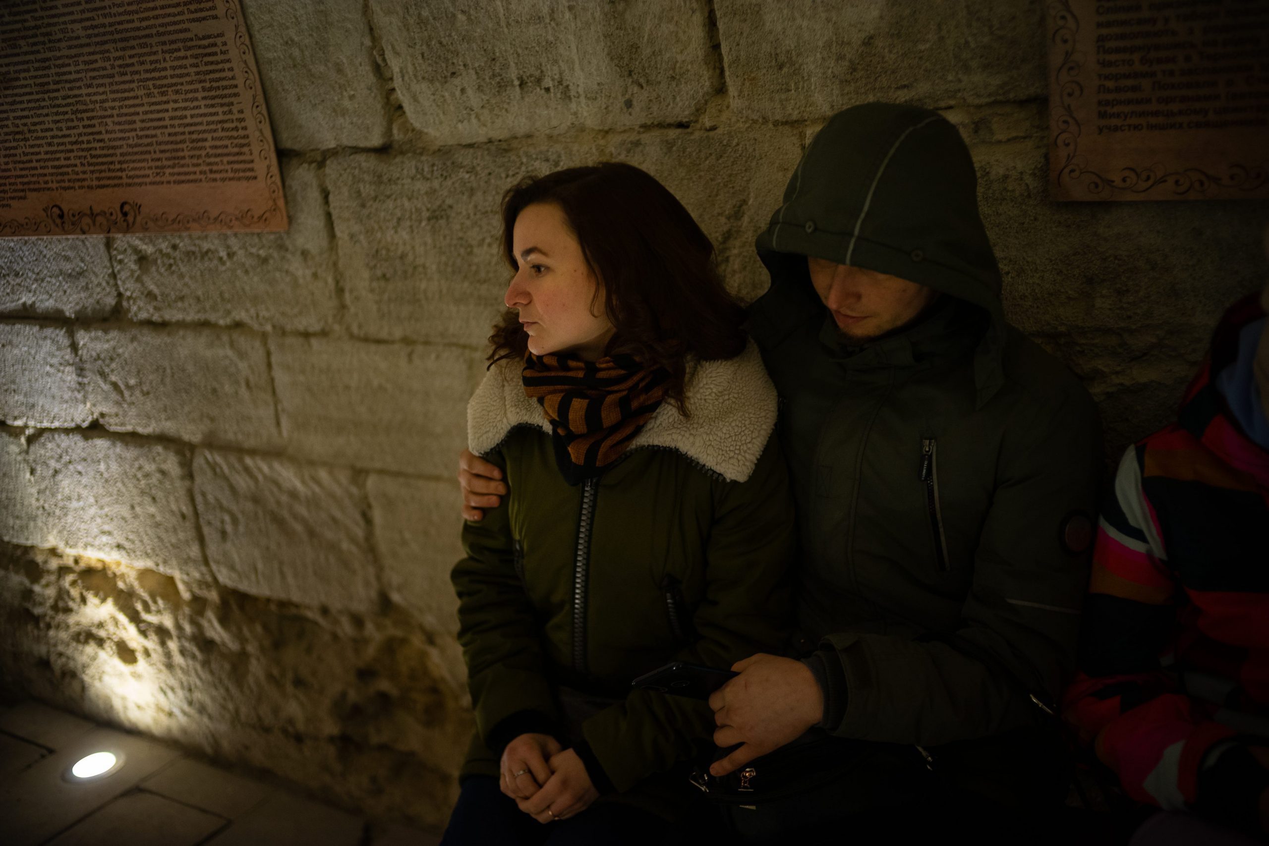 Worried couple sitting inside the Cathedral of the Conception of the Blessed Virgin Mary air raid shelter.