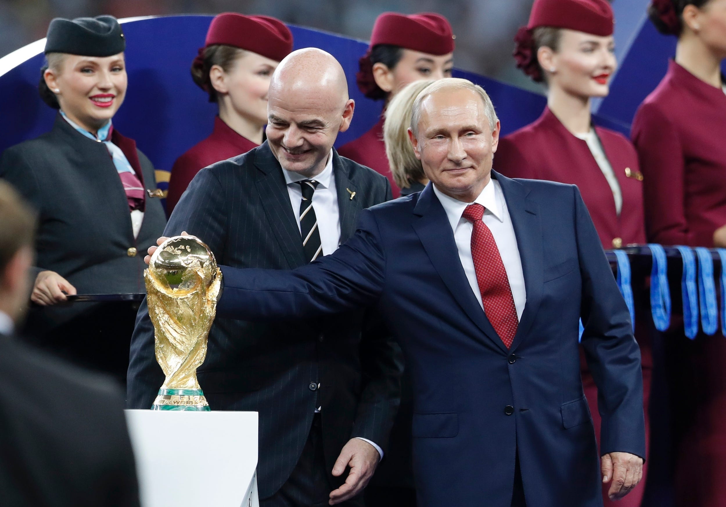 Vladimir Putin touches the World Cup trophy at the 2018 final in Moscow.