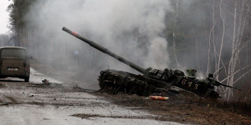 Smoke rises from a Russian tank destroyed by the Ukrainian forces on the side of a road in Lugansk region on February 26, 2022.