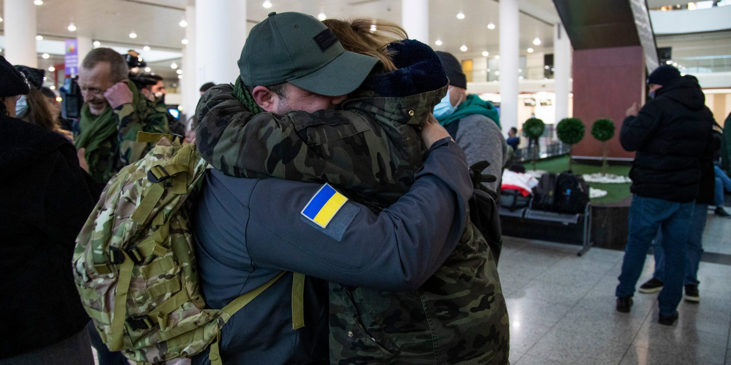 Men hug at airport on way to fight in Ukraine