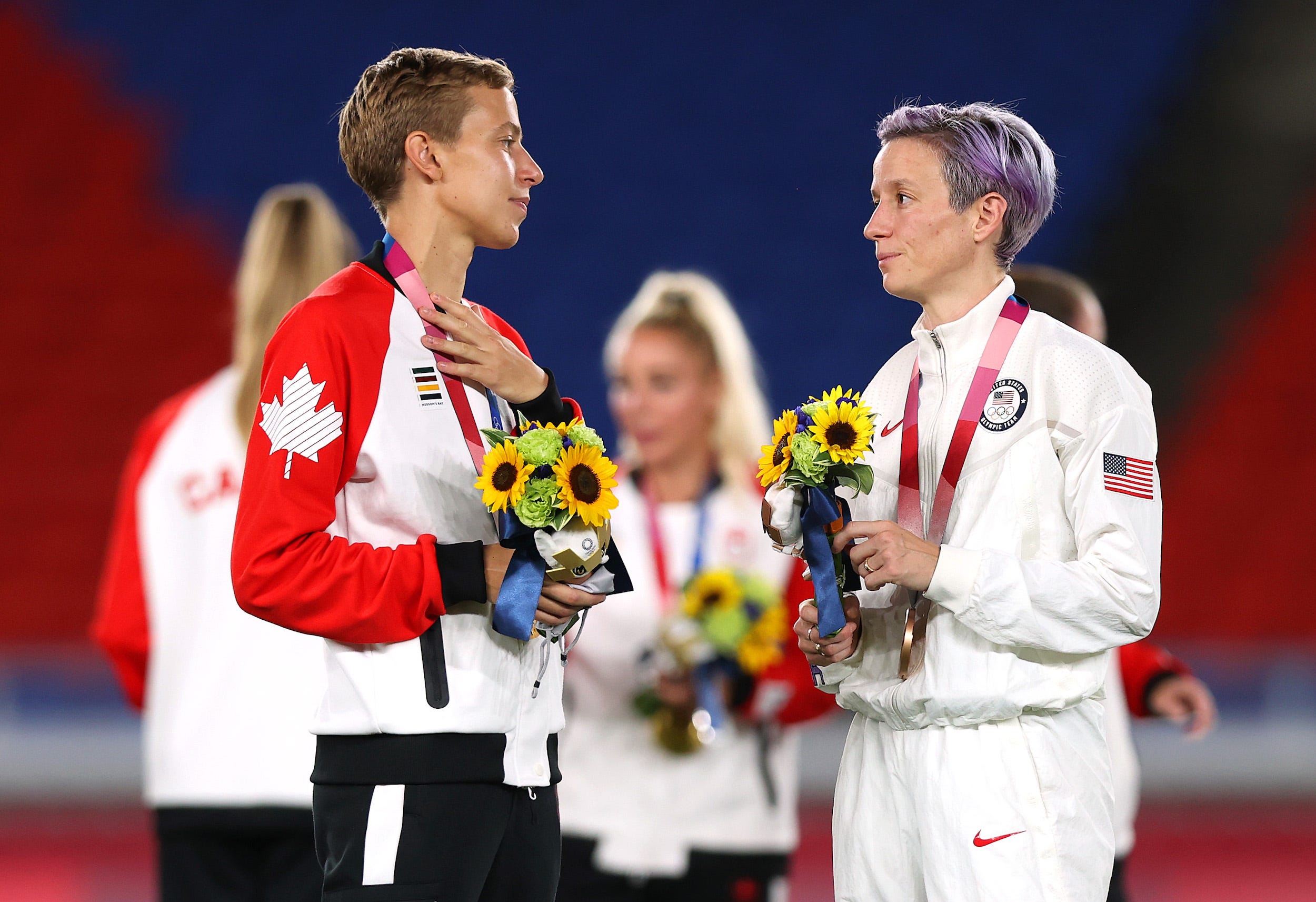 Canada's Quinn speaks with USWNT's Megan Rapinoe.