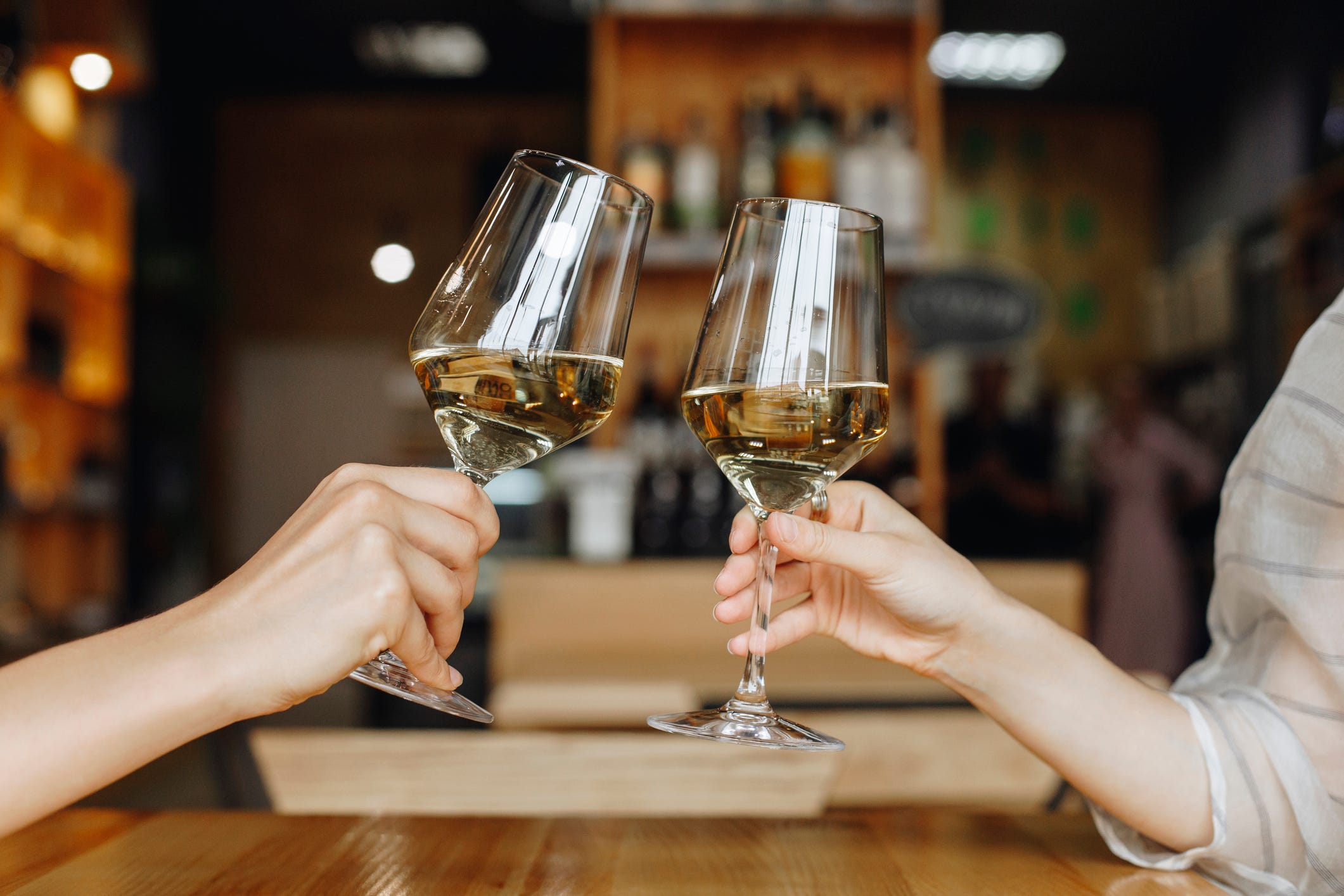 People toasting with white wine.