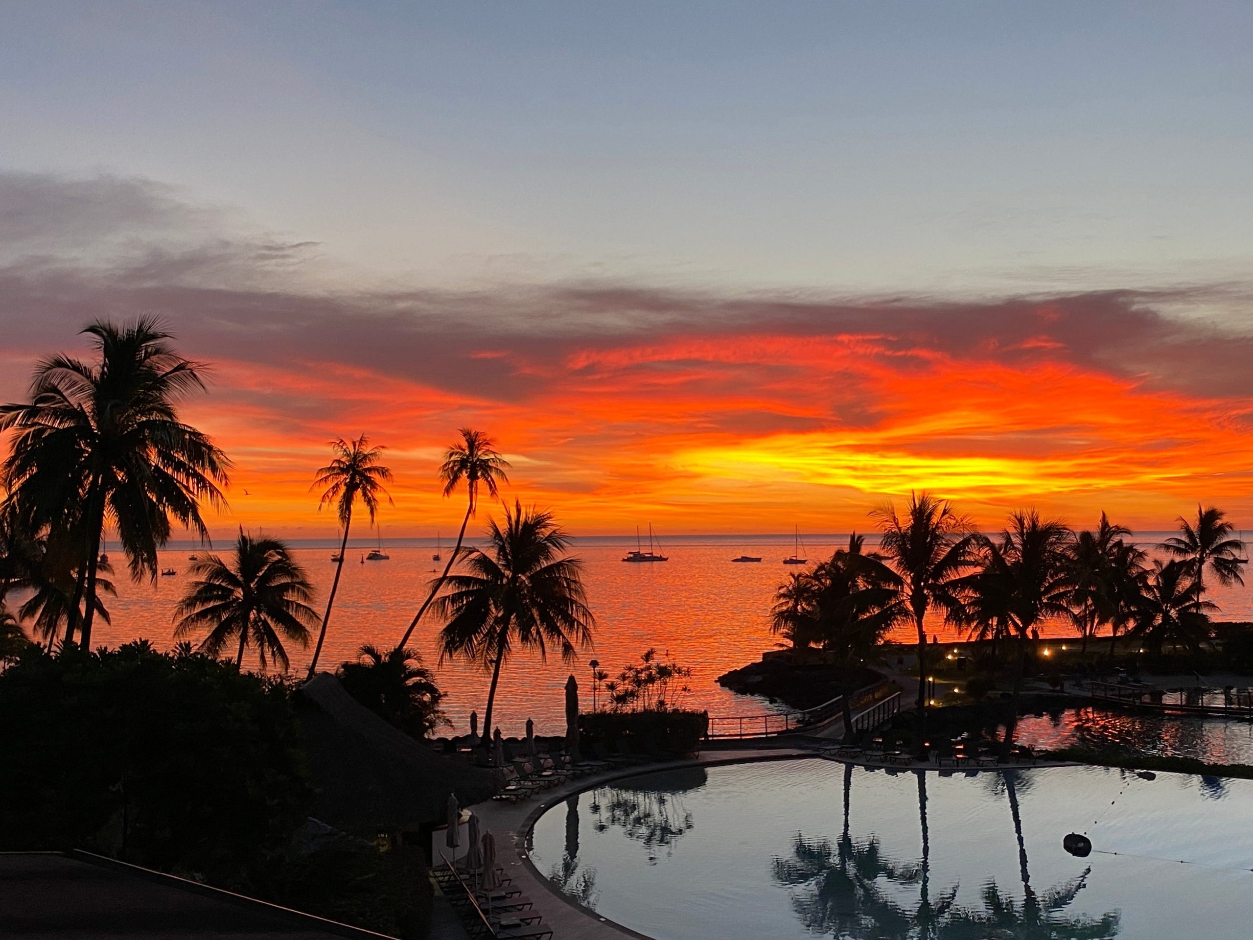 A sunset over the pool and beach at the InterContinental Tahiti Resort & Spa.