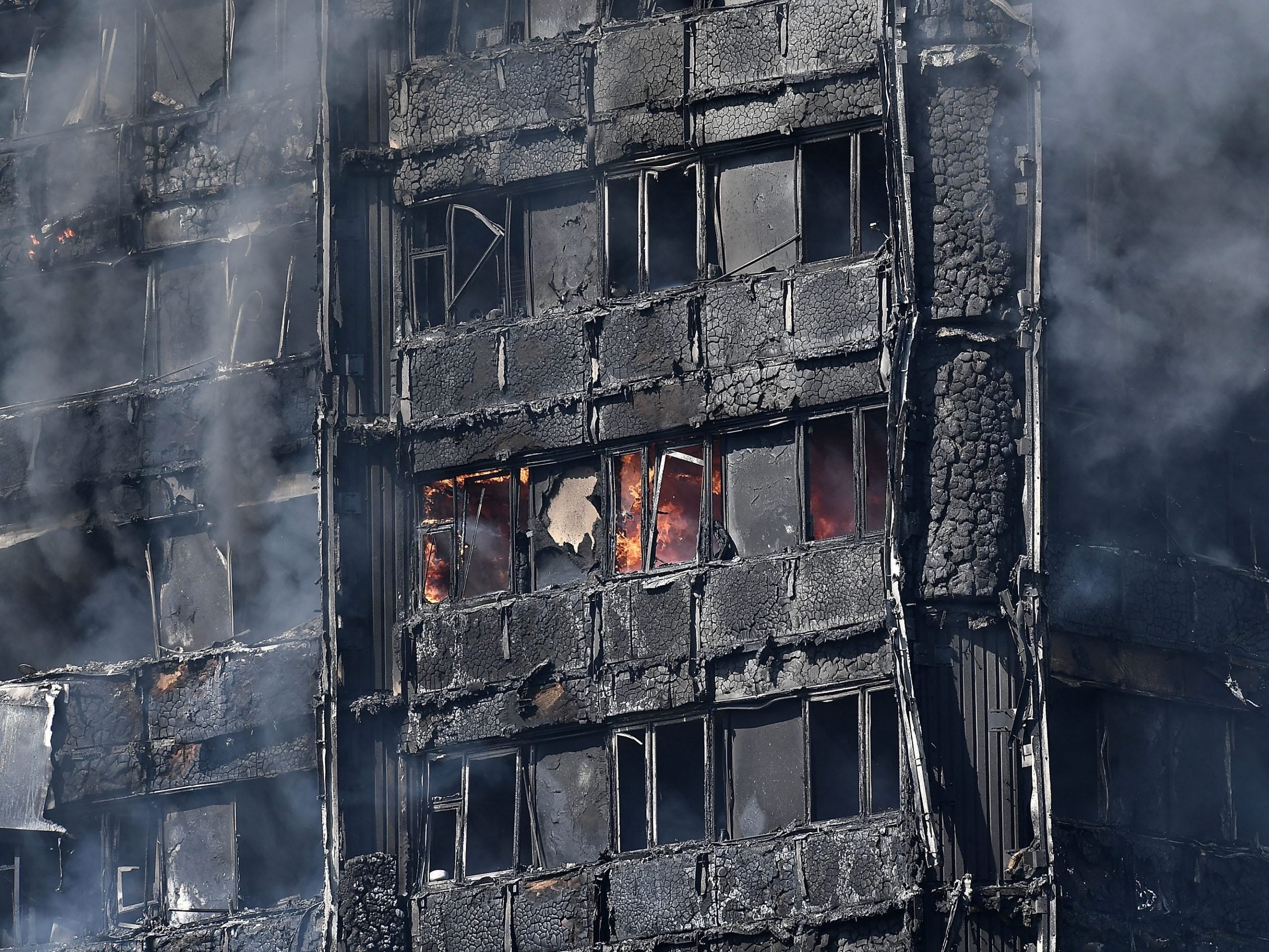 Smoke rises from the burning 24 storey residential Grenfell Tower block in Latimer Road, West London on June 14, 2017 in London, England.