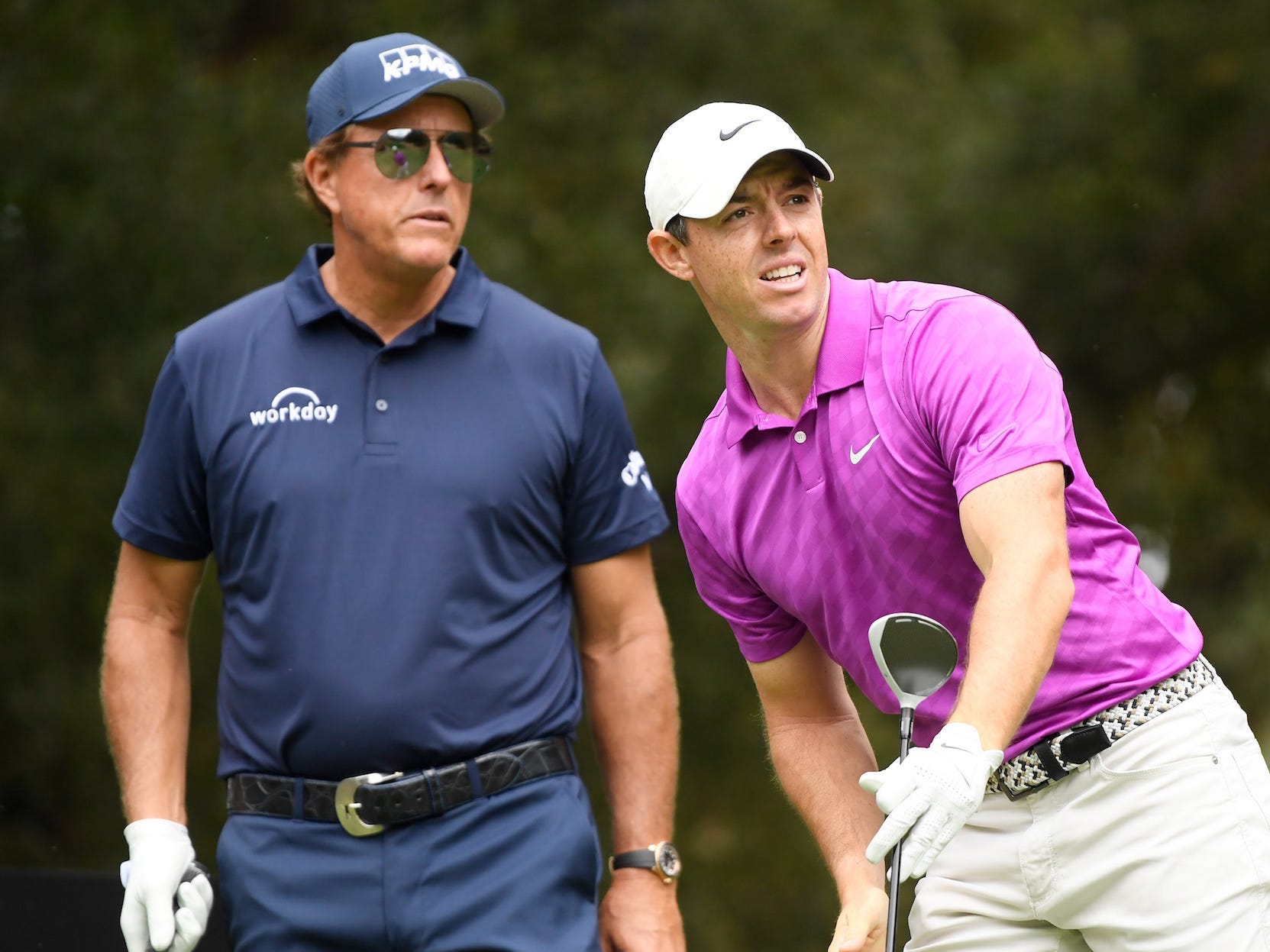 Rory McIlroy of Northern Ireland watches his shot from the sixth tee as Phil Mickelson of the United States looks on during the first round of the Zozo Championship @ Sherwood