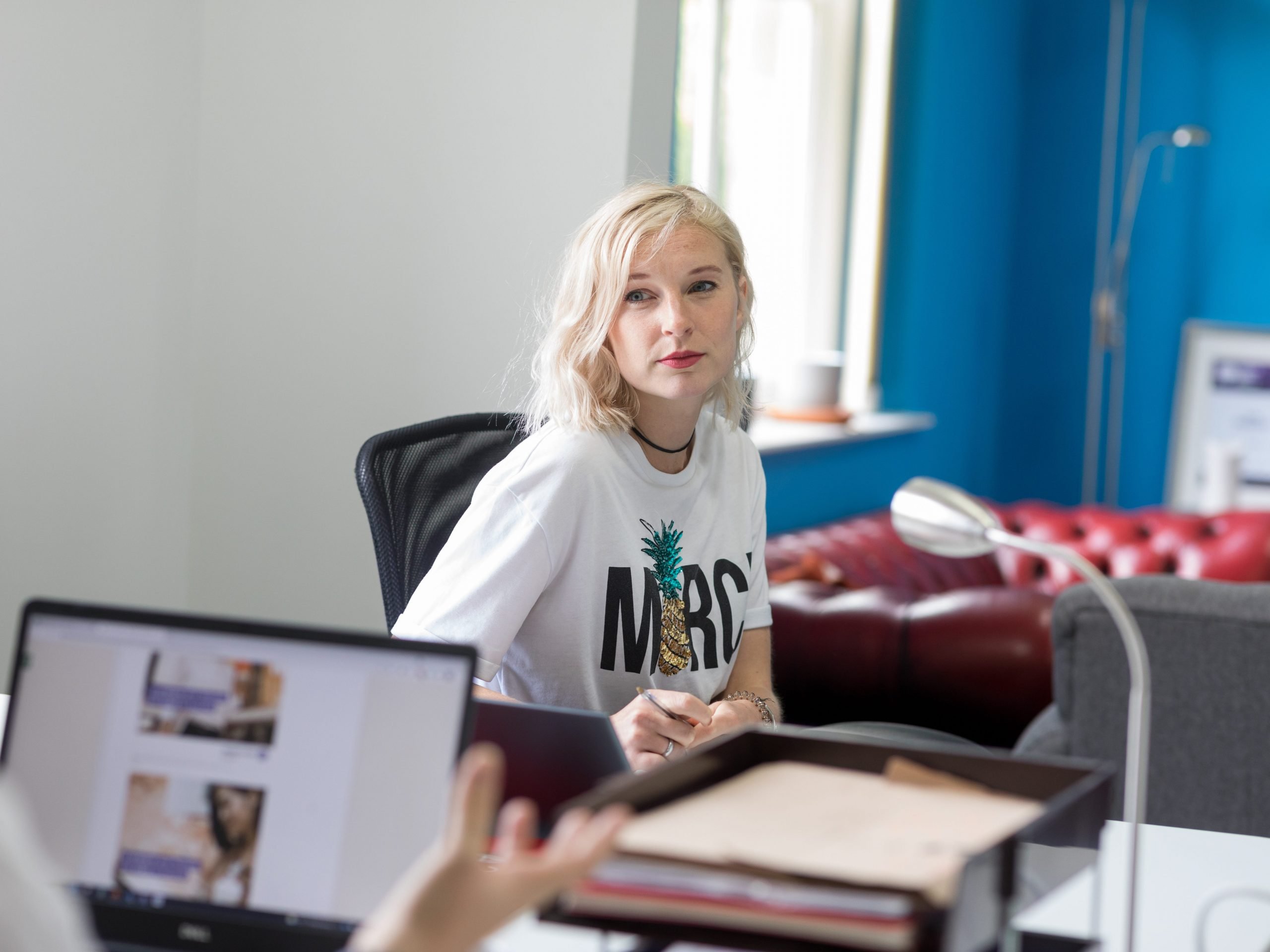 Woman with blonde hair and white t-shirt in an office