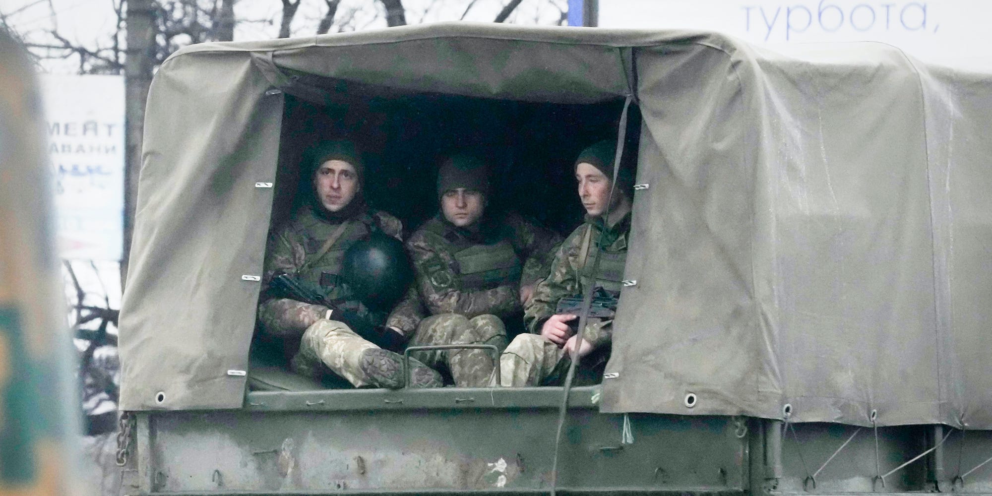 Ukrainian soldiers ride in a military vehicle