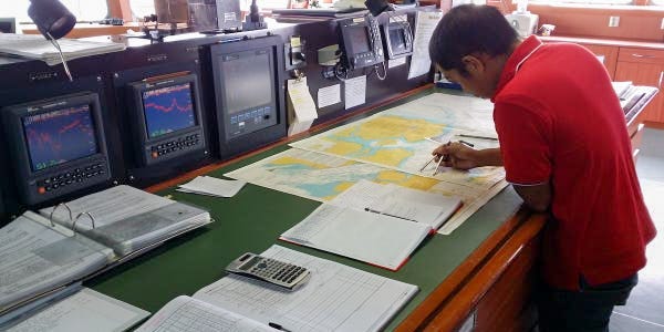 Een bemanningslid kijkt naar een kaart op de Amerigo Vespucci