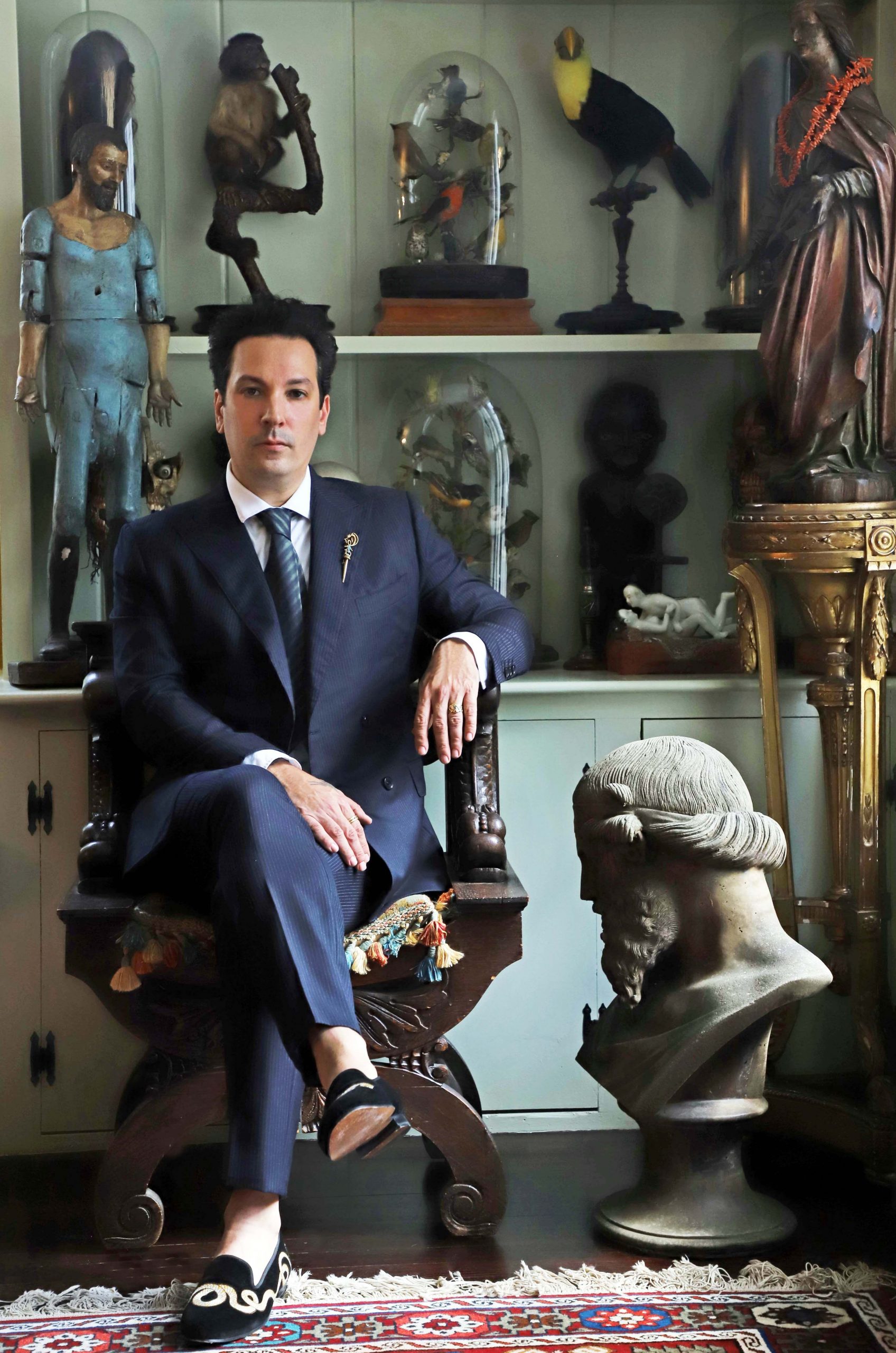 Ryan Matthew Cohn posing in front of antique sculptures.