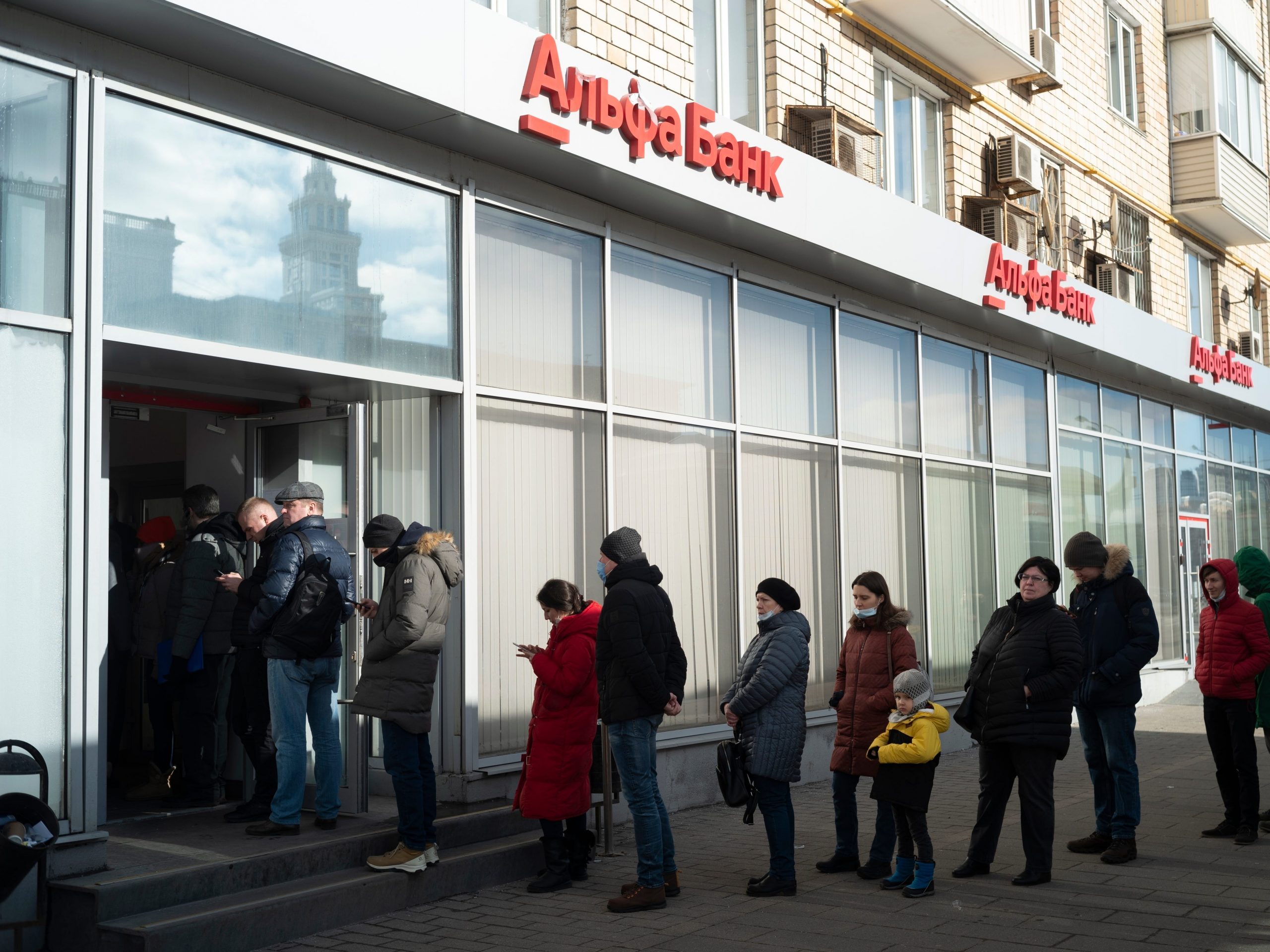 People stand in line to withdraw money from an ATM of Alfa Bank in Moscow, Russia, Sunday, Feb. 27, 2022.