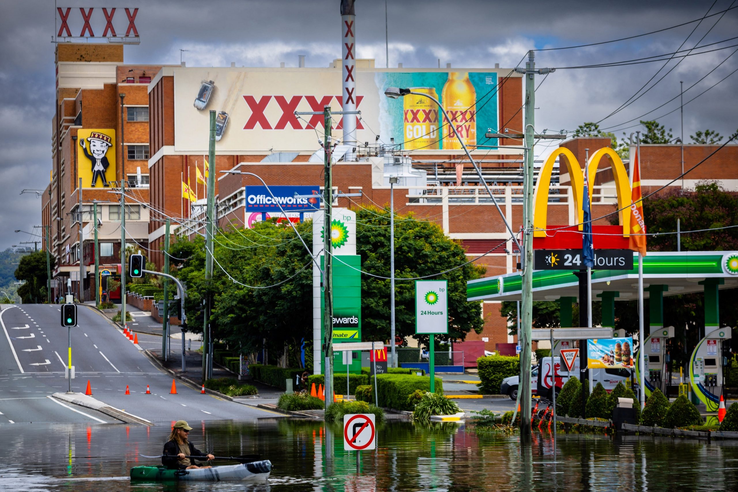 A man paddles his kayak along a flooded street, in the town of Milton in suburban Brisbane on February 28, 2022