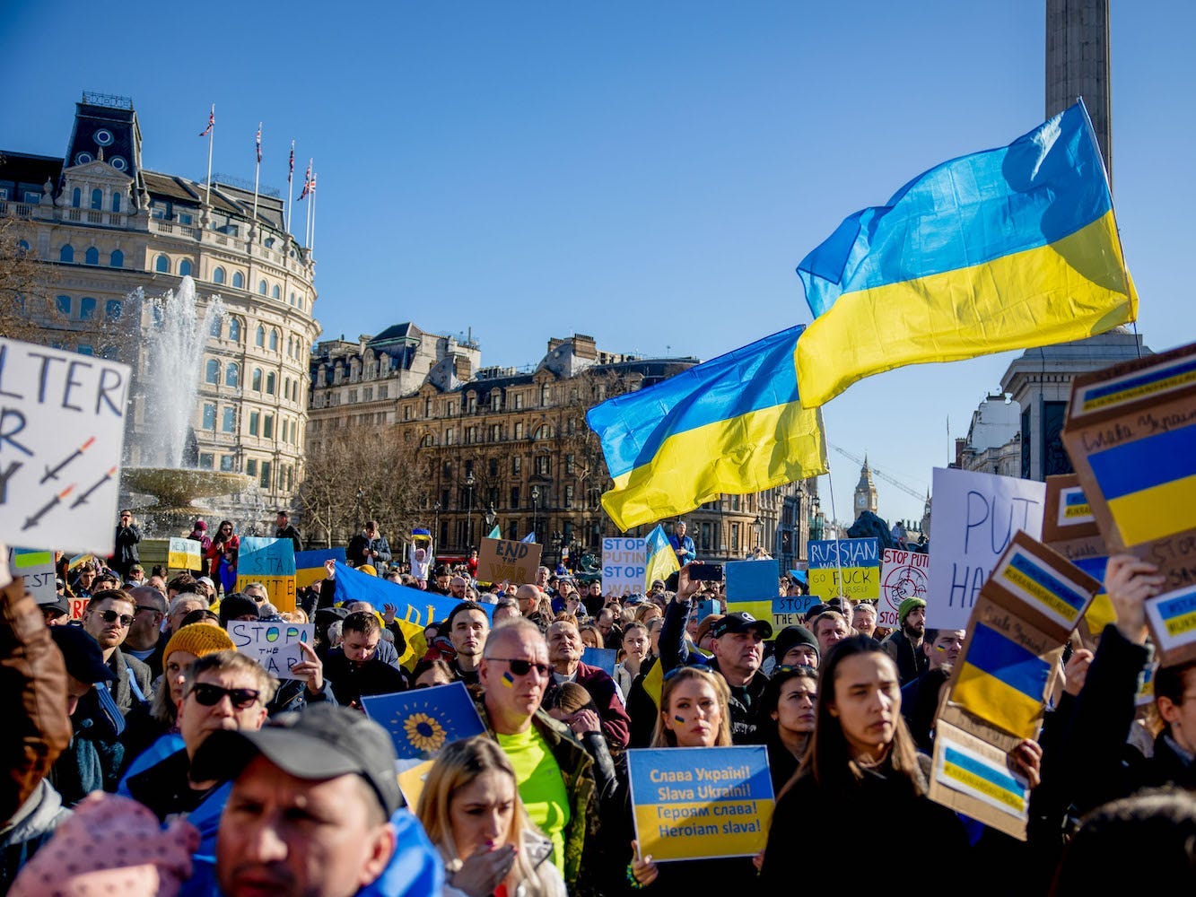 Protestors hold placards and Ukrainan flags at an an anti war protest against the invasion of Ukraine, in London.