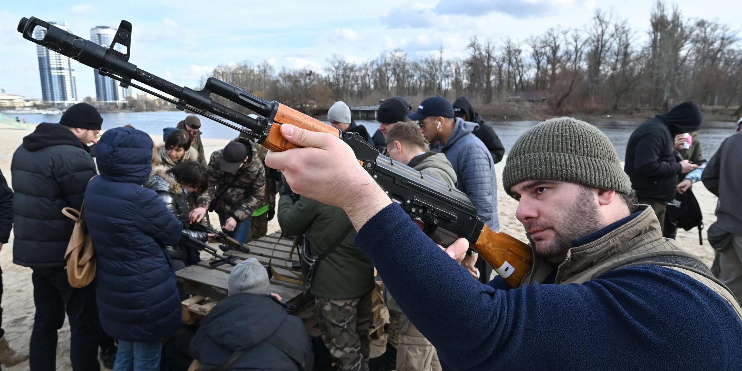 Residents attend an open training organised for civilians by war veterans and volunteers who teach the basic weapons handling and first aid on one of Kiyv's city beaches on February 20, 2022, amid soaring tensions with Russia.