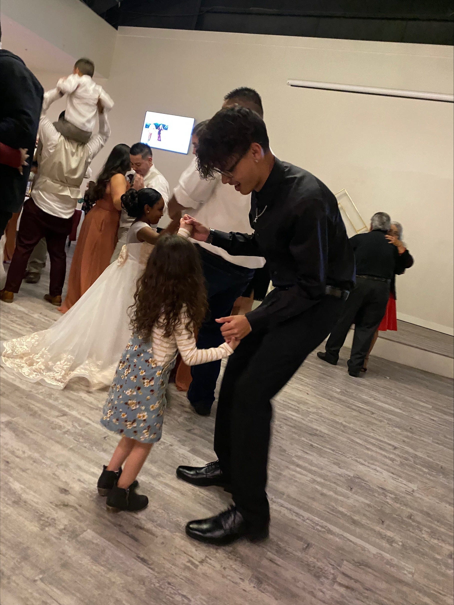 Abie Martinez dancing with a little girl at a wedding