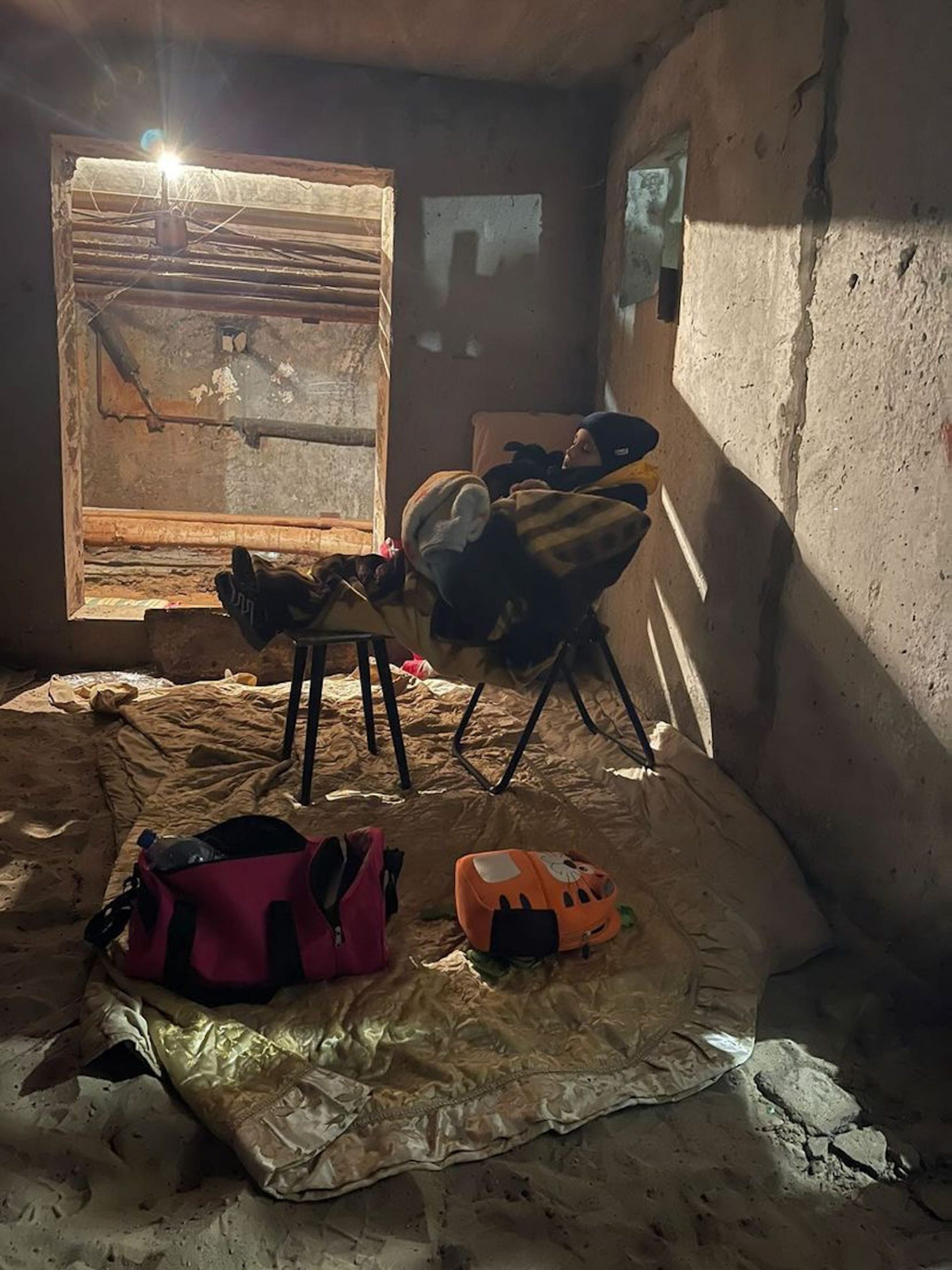 A boy sleeps on a chair in a basement