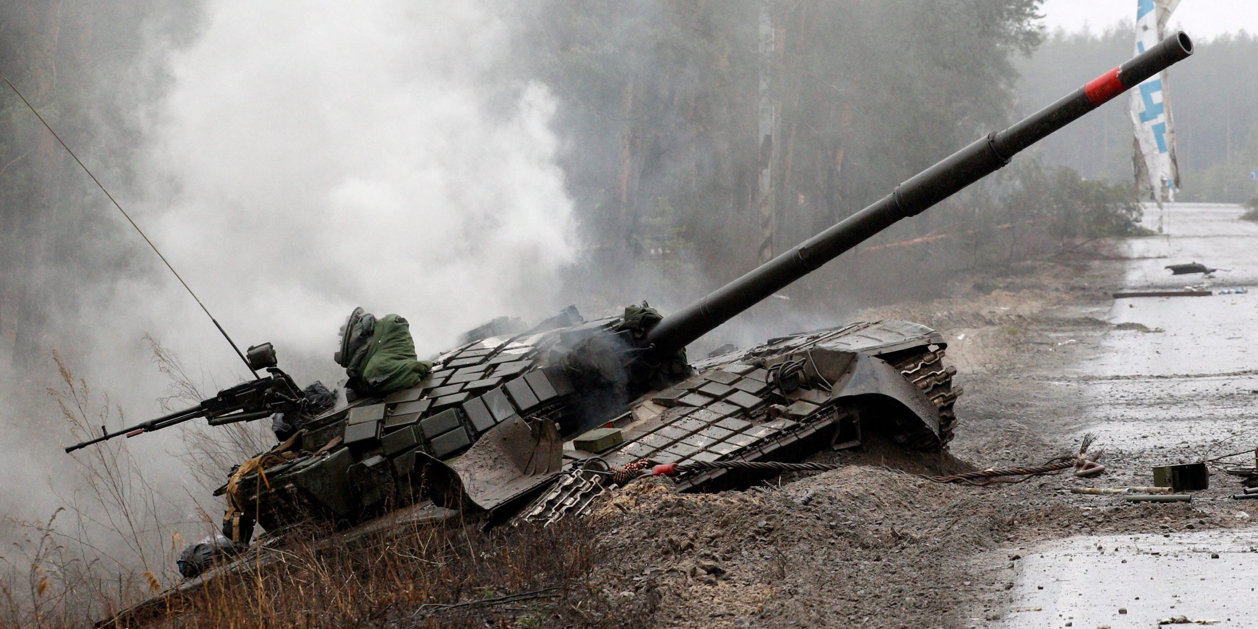 Smoke rises from a Russian tank destroyed by the Ukrainian forces on the side of a road in Lugansk region.