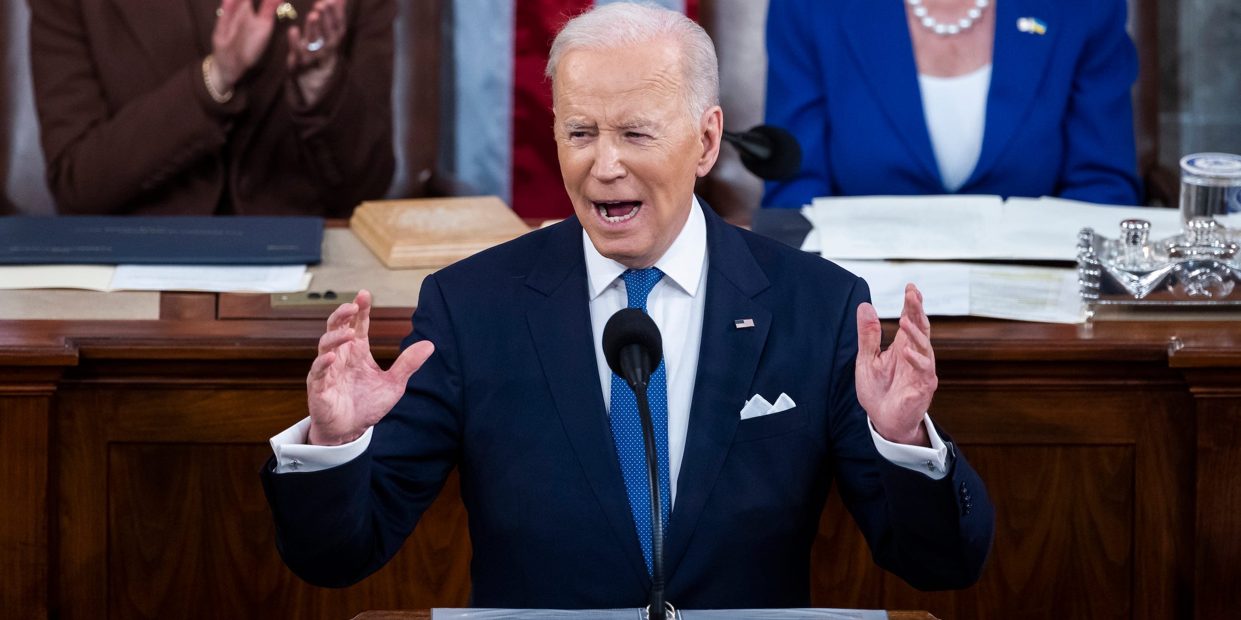 President Joe Biden with both hands in the air up to his shoulders.