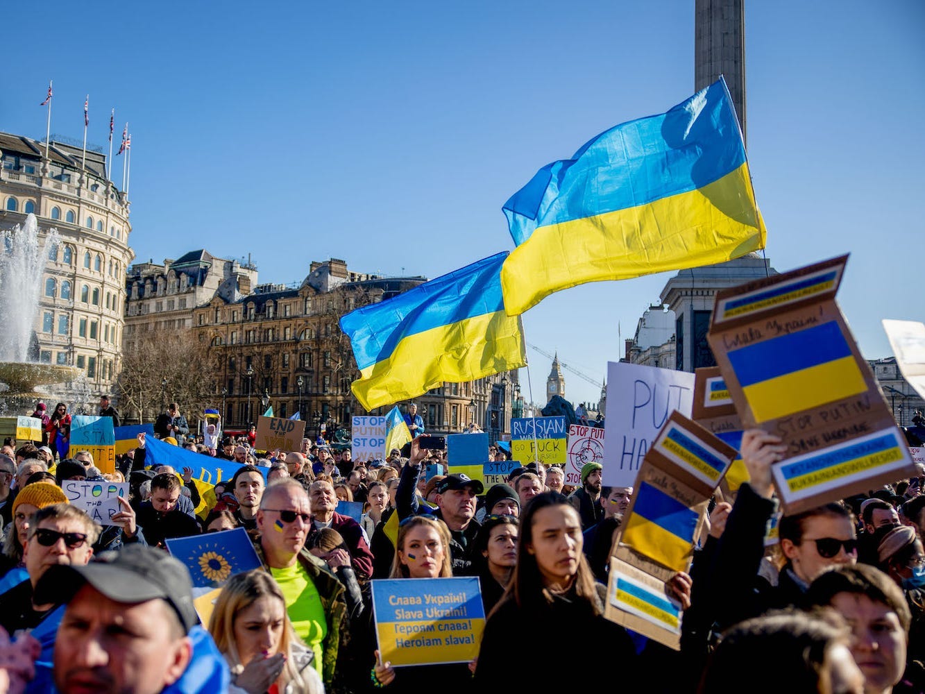 Protestors hold placards and Ukrainan flags at an an anti war protest against the invasion of Ukraine, in London.