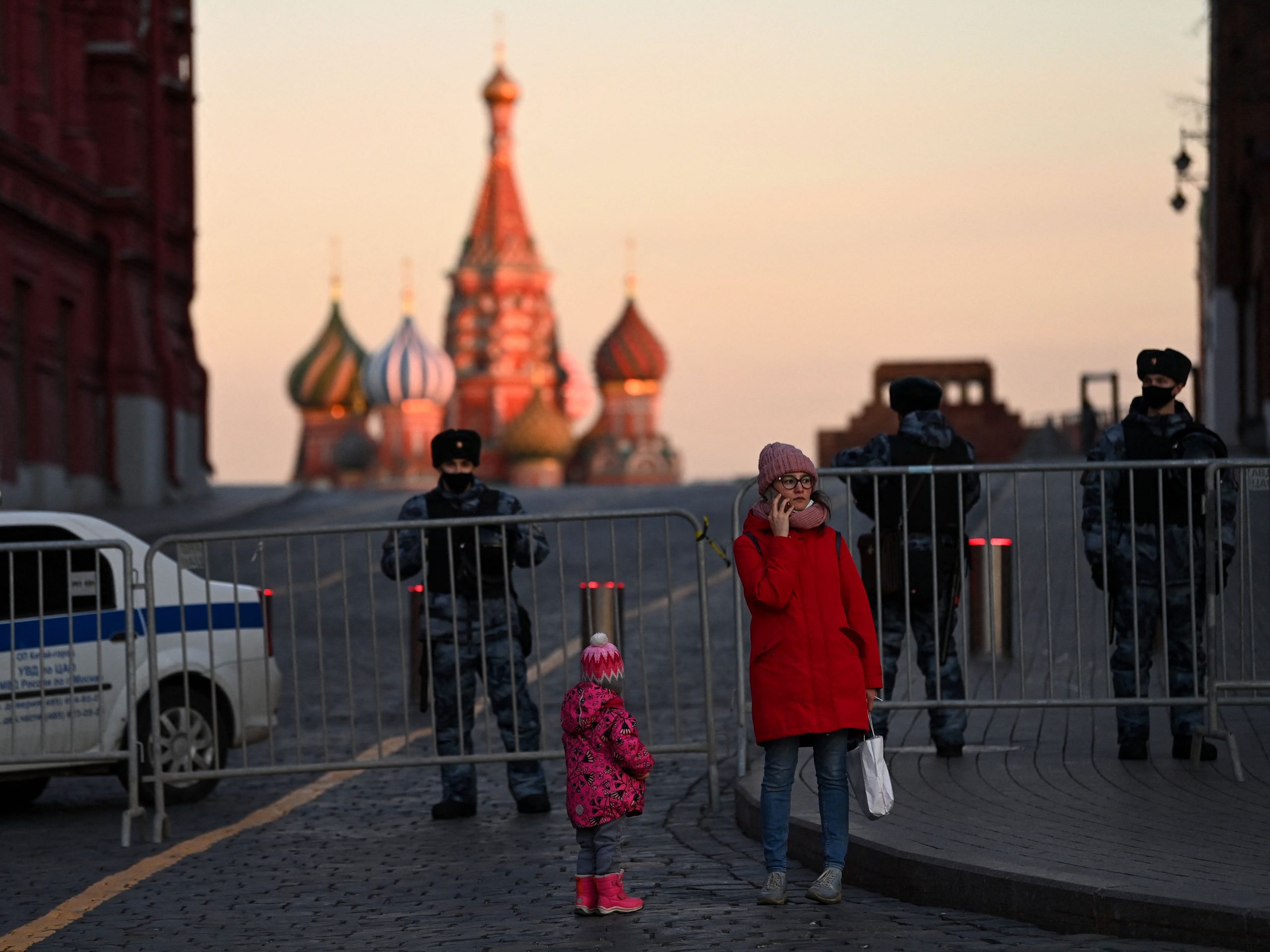 A woman makes a phone call in front of police officers blocking access to Red Square in central Moscow on March 2, 2022