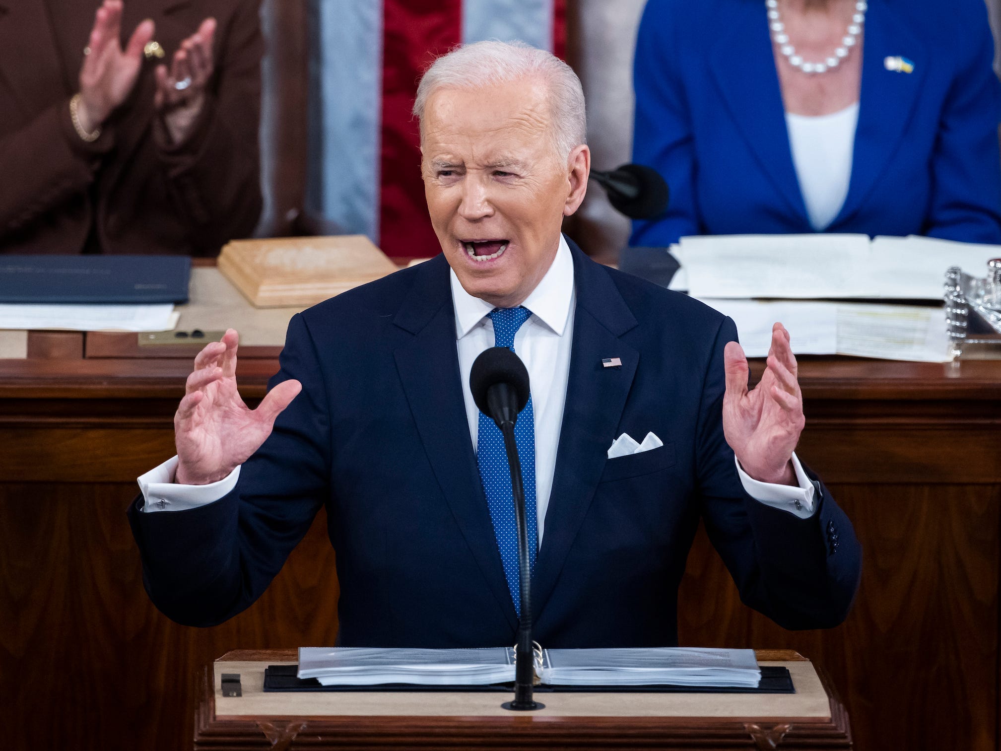 President Joe Biden with both hands in the air up to his shoulders.