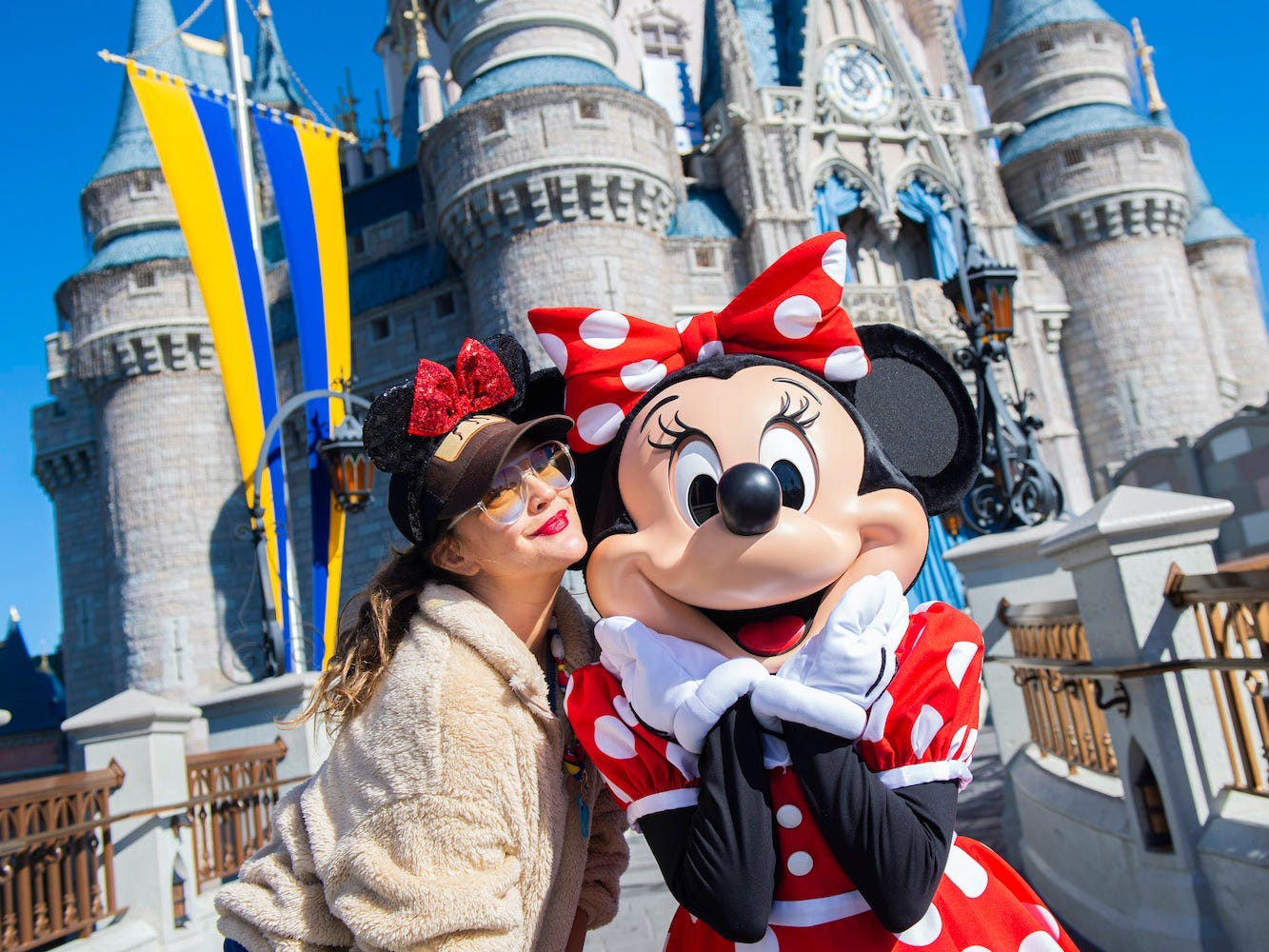 Drew Barrymore strikes a pose with Minnie Mouse while vacationing with family at Magic Kingdom Park in Walt Disney World Resort.