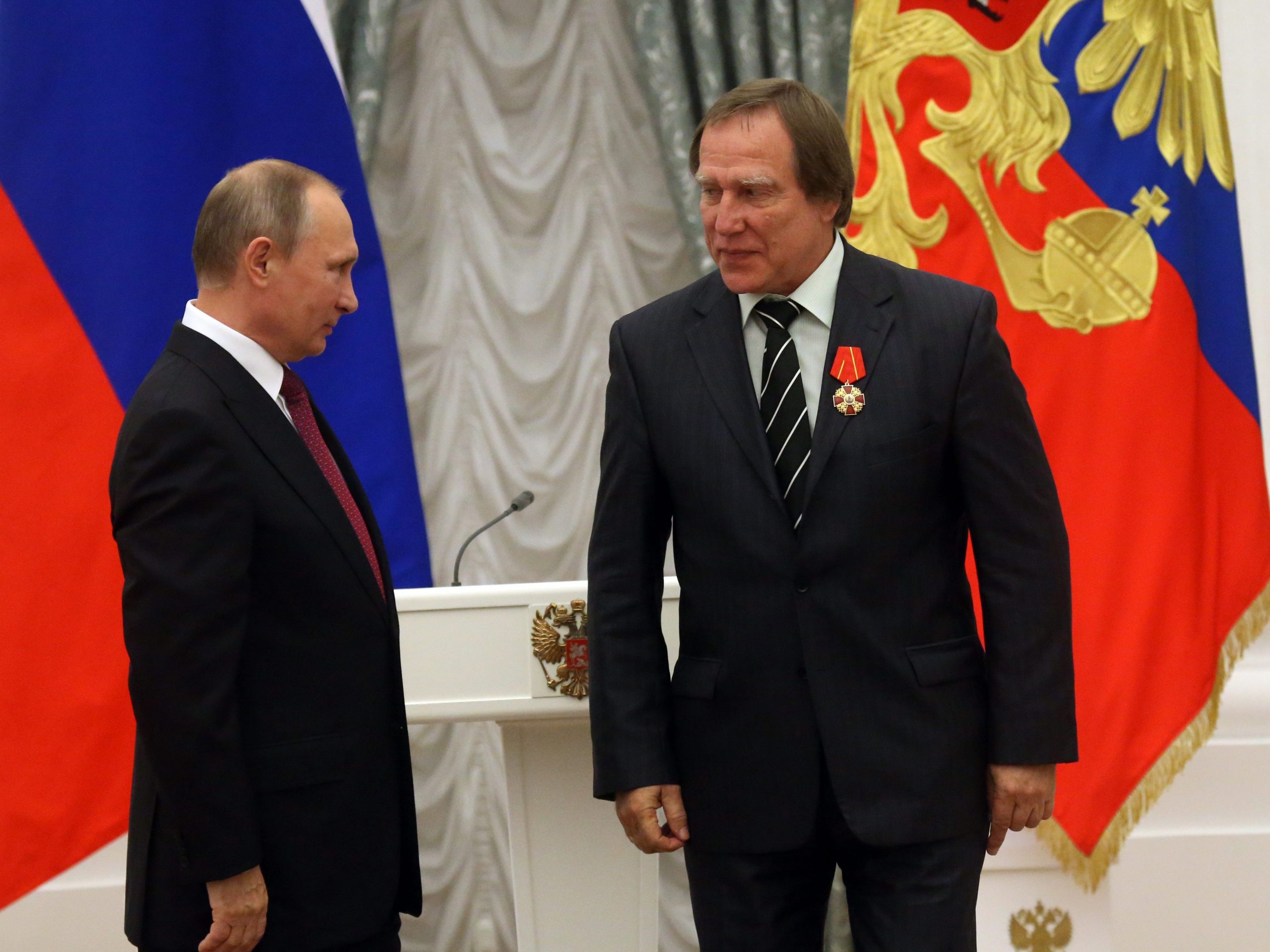 De Russische president Vladimir Poetin (L) kent zakenman en cellist Sergej Roldoegin (R) een onderscheiding toe in het Kremlin in 2016.