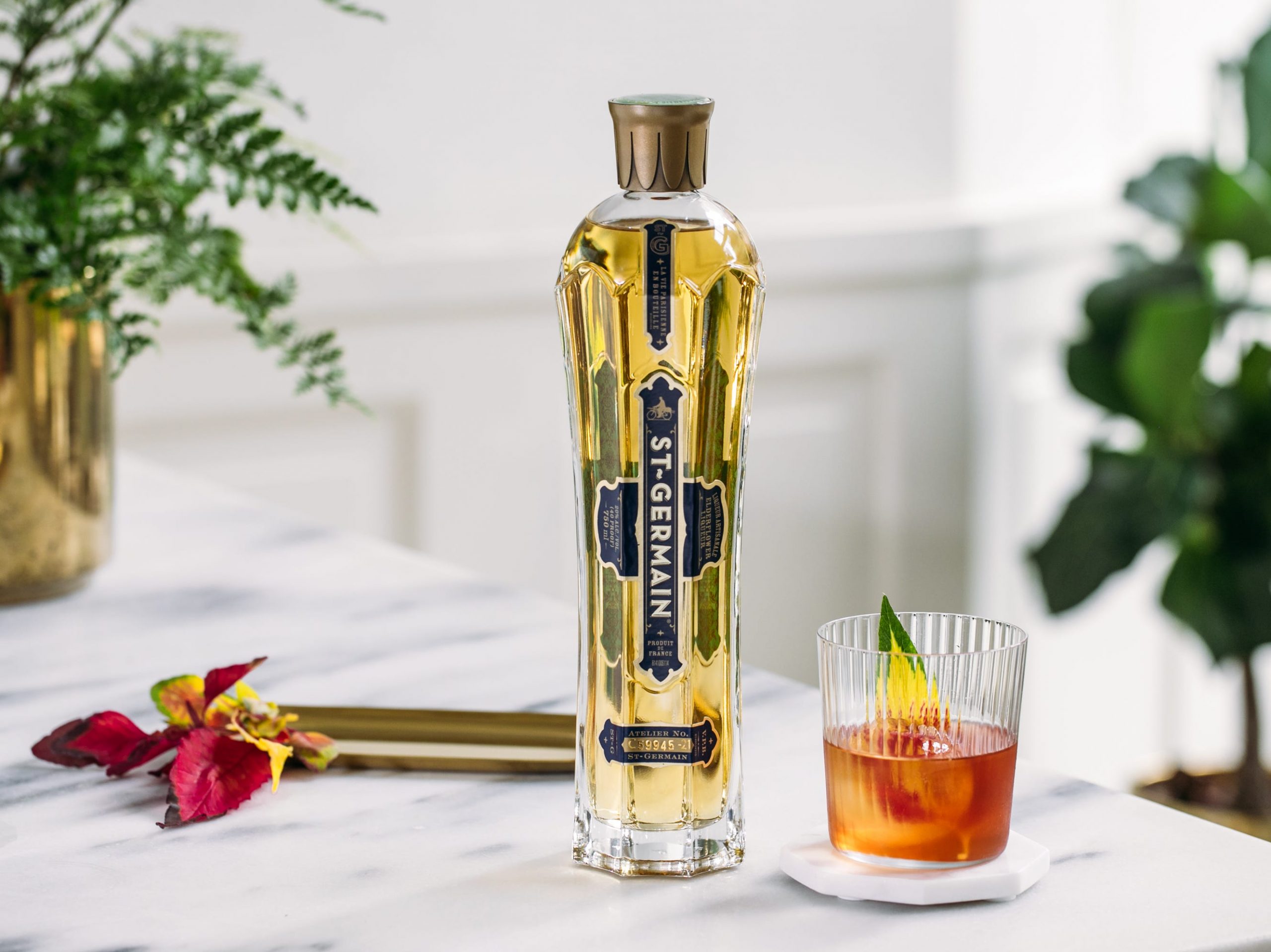 St. Germain bottle with an elder fashioned cocktail next to it