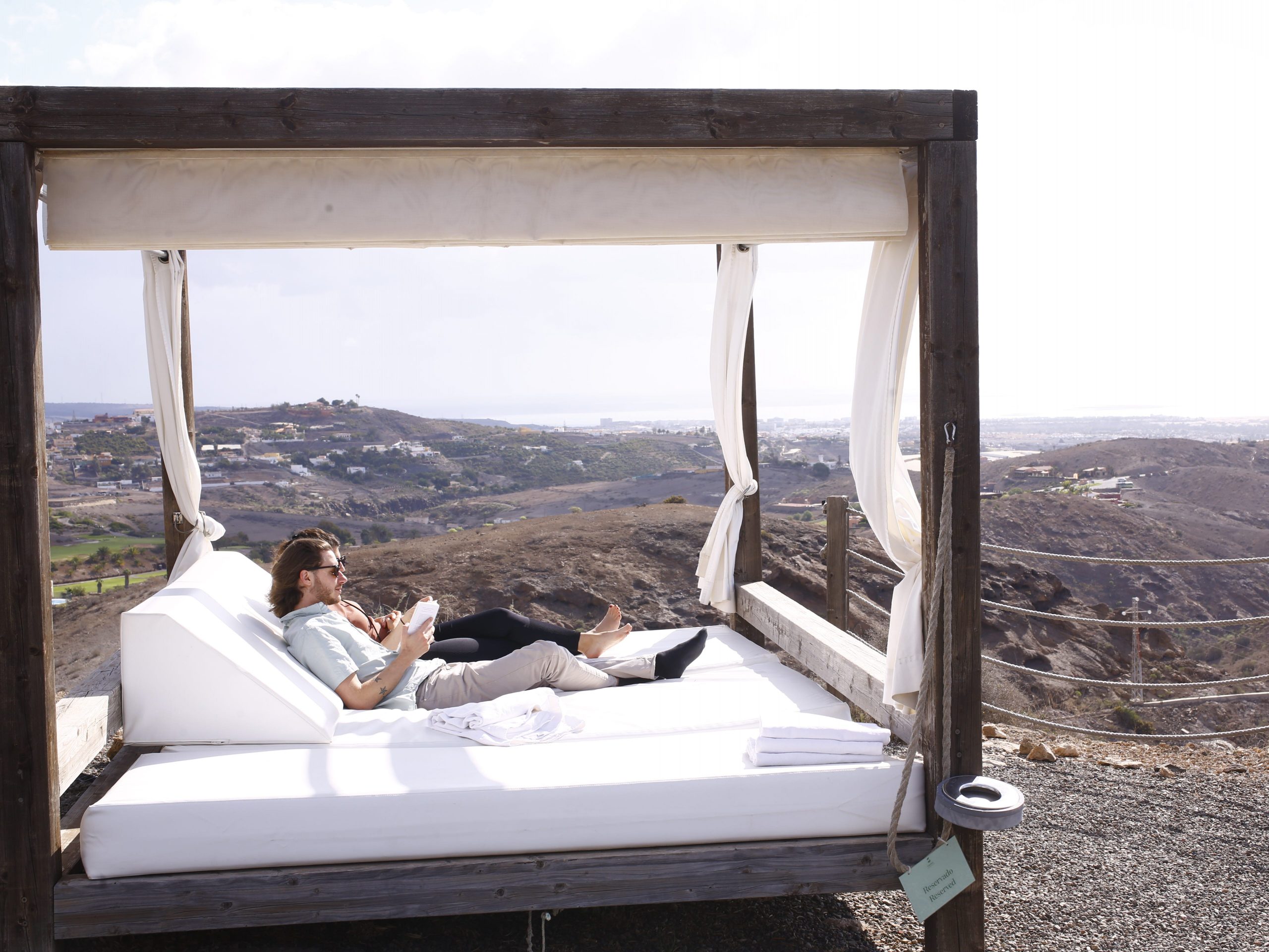 A couple sitting in a cabana overlooking the view of Gran Canaria, Canary Islands