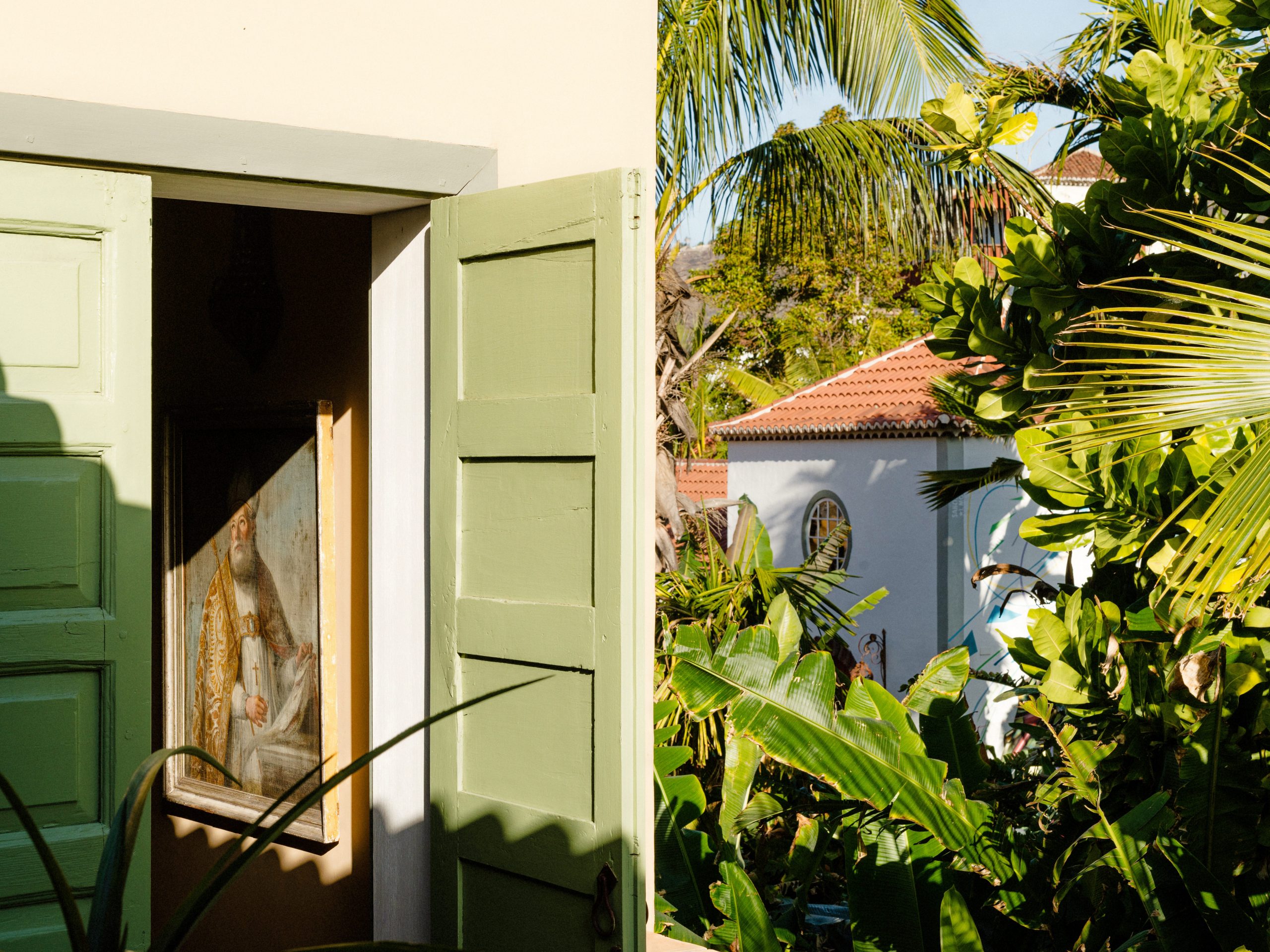 A building surrounded by leafy plants and trees at Hotel Hacienda de Abajo on Canary Island.