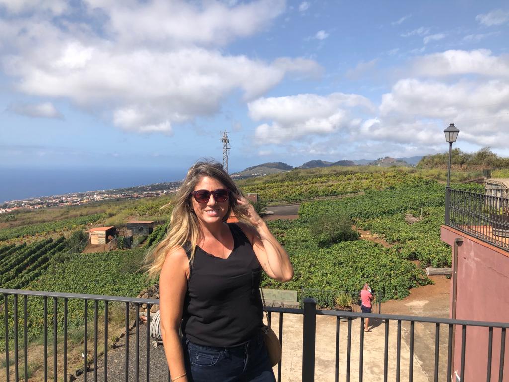 A woman posing in front of lush green scenery in the Canary Islands