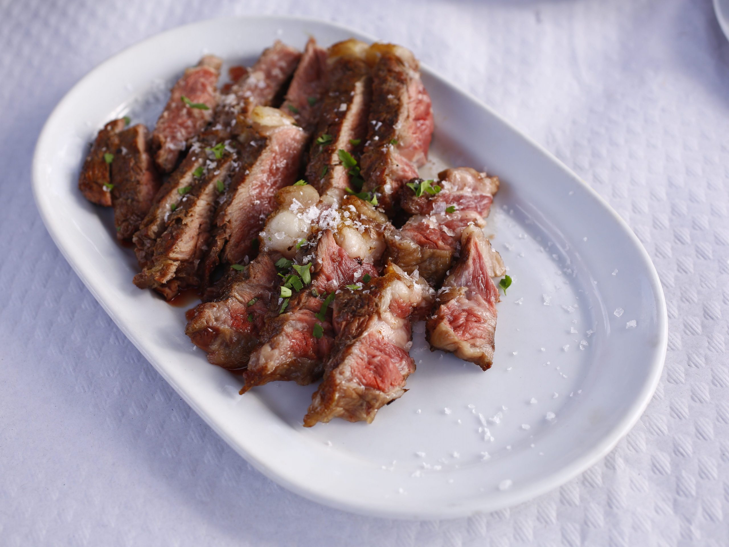 Cooked beef in a small white dish.