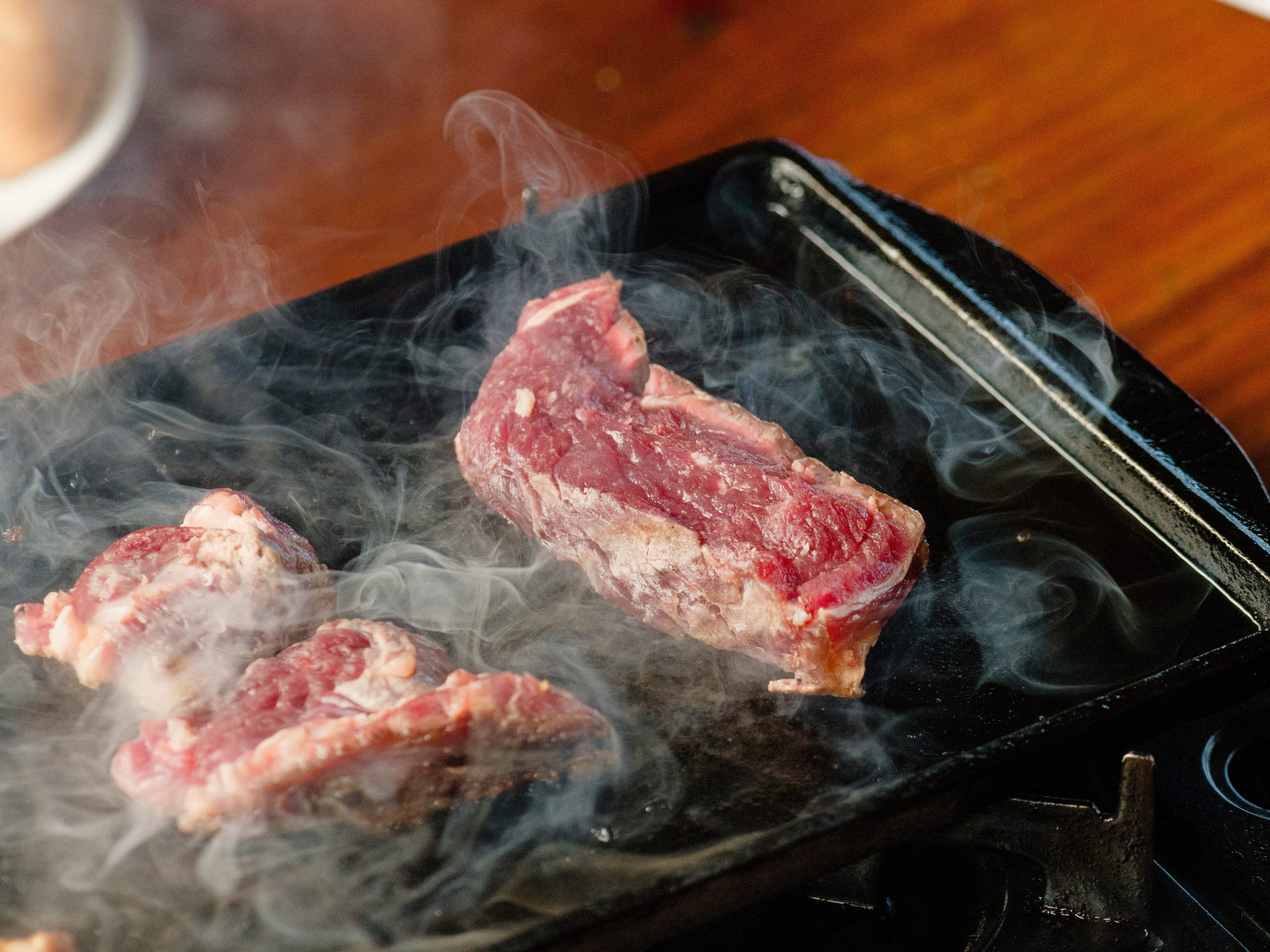 A two pieces of meat grilling on a plate.