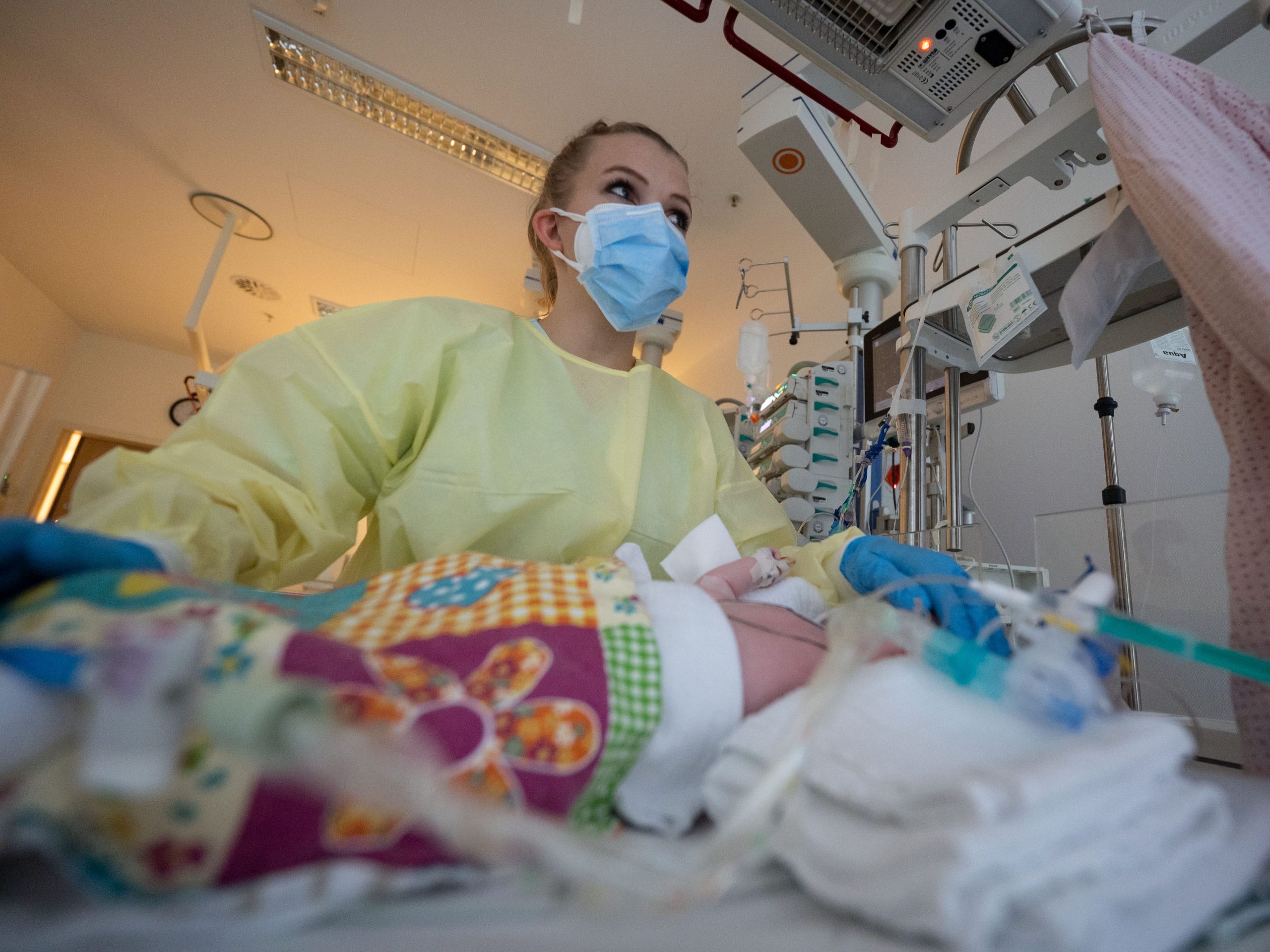 Intensive care nurse cares for a patient suffering from respiratory syncytial virus (RS virus or RSV) who is being ventilated in the children's intensive care unit in Germany.